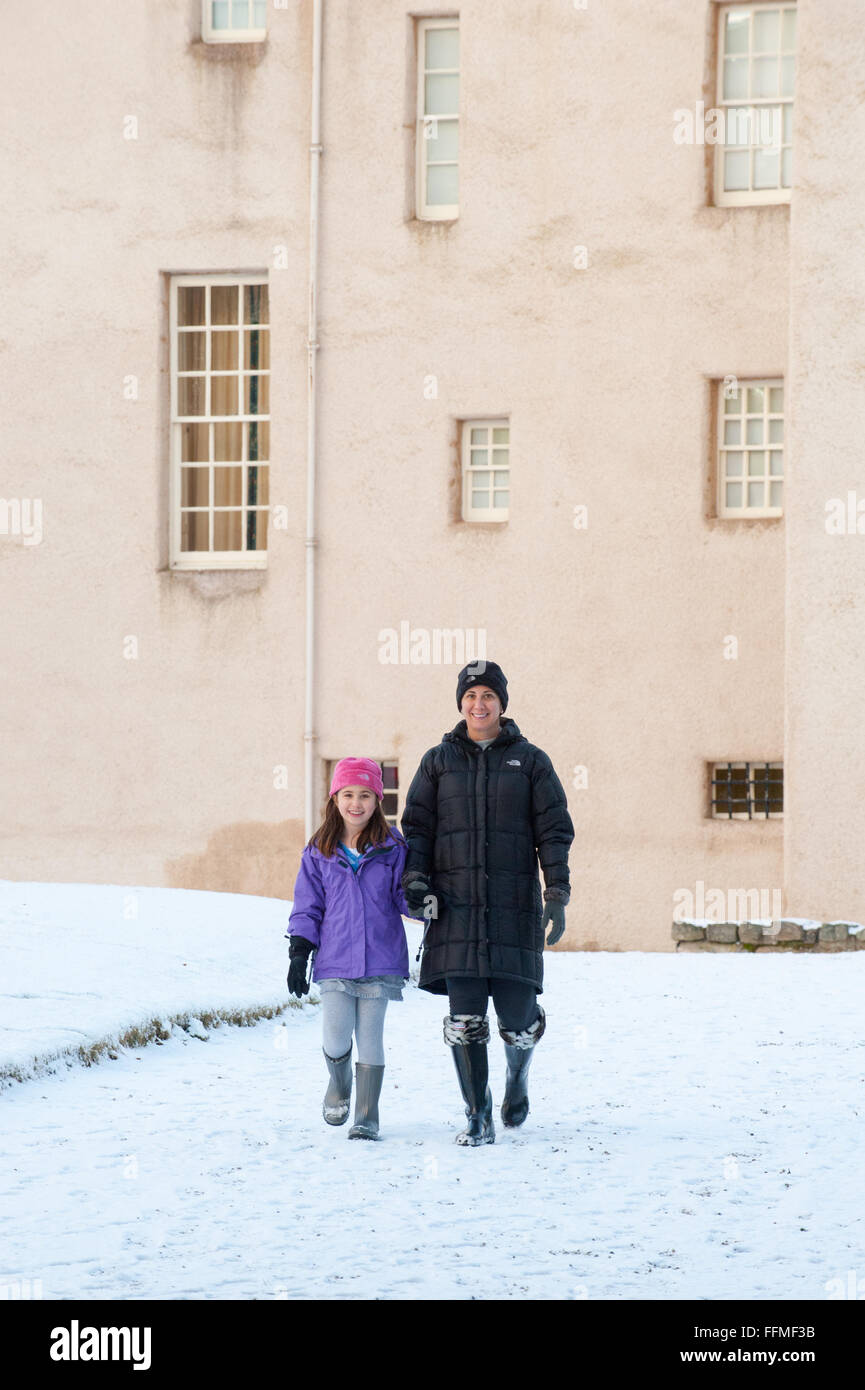 Mutter und Tochter Spaziergang im Schnee auf der Trommel Burg in Aberdeenshire, Schottland. Stockfoto
