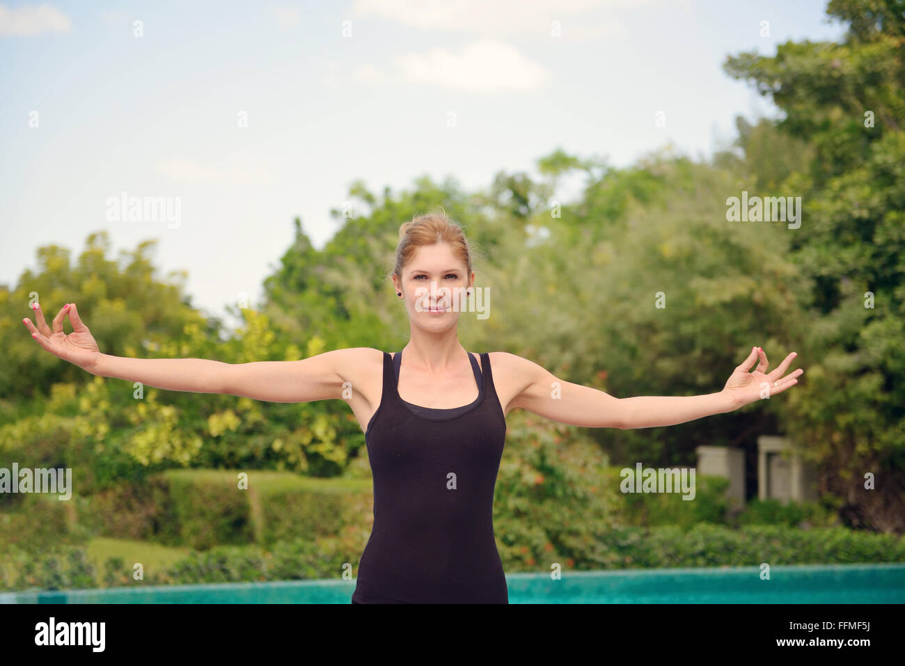 Frau beim Yoga am Pool in Dubai Stockfoto