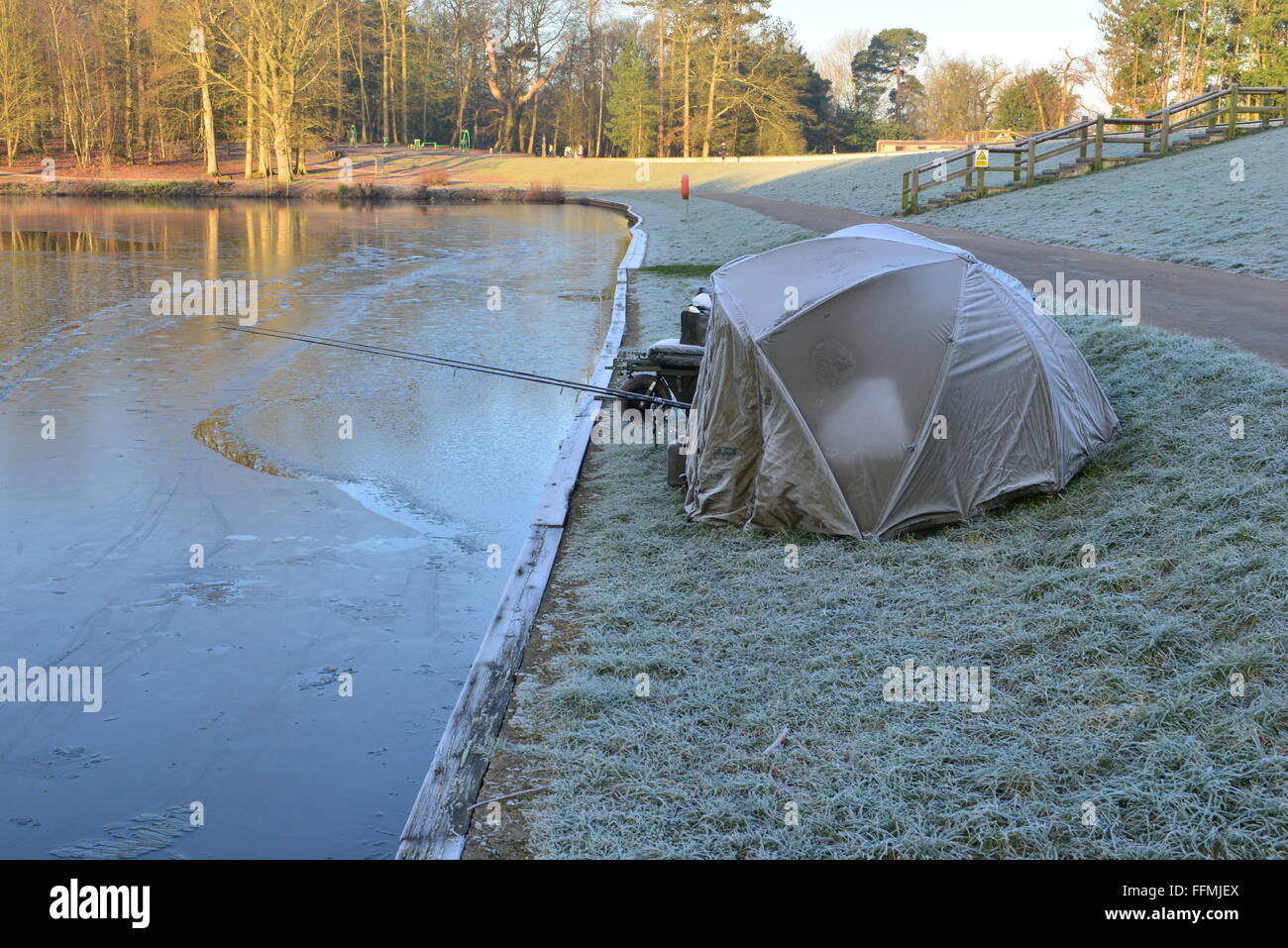 Ein Fischer im Biwak an der Seite eines Sees im Winter schläft, Stockfoto