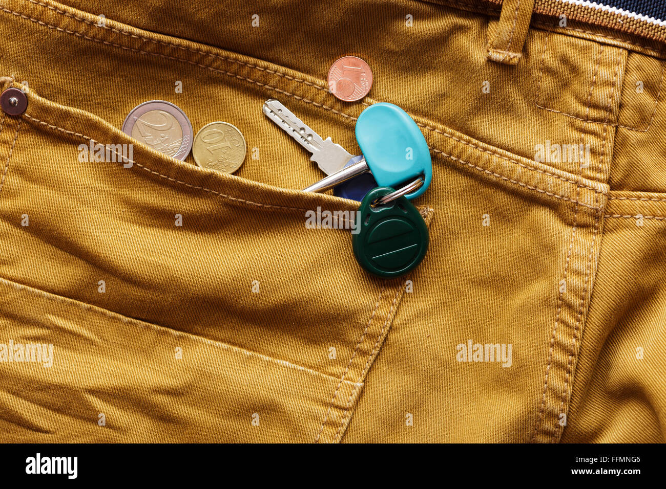 Schlüssel und Münzen in der Gesäßtasche der Jeans. Stockfoto