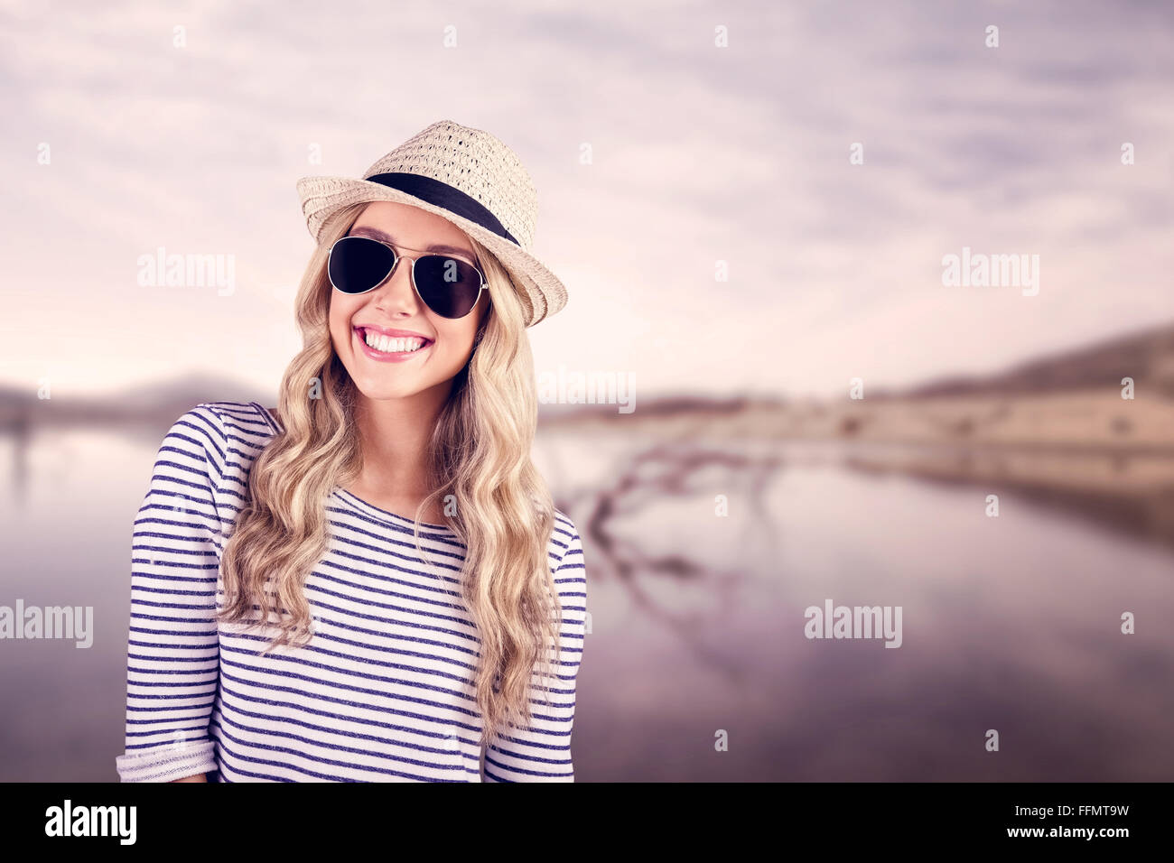 Wunderschöne lächelnde blonde Hipster mit Sonnenbrille und Strohhut Stockfoto