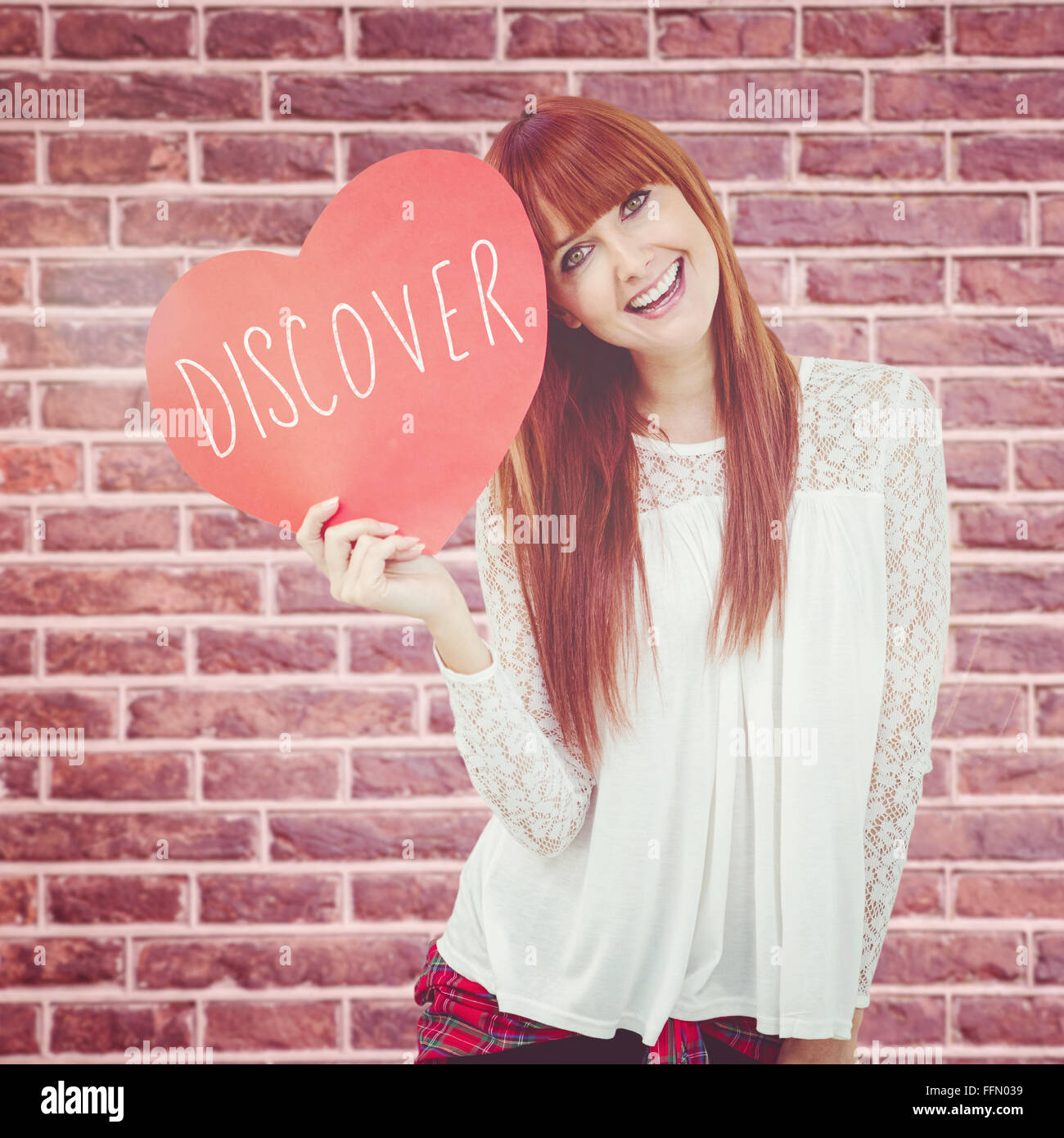 Zusammengesetztes Bild des Lächelns Hipster-Frau mit einem großen roten Herzen Stockfoto