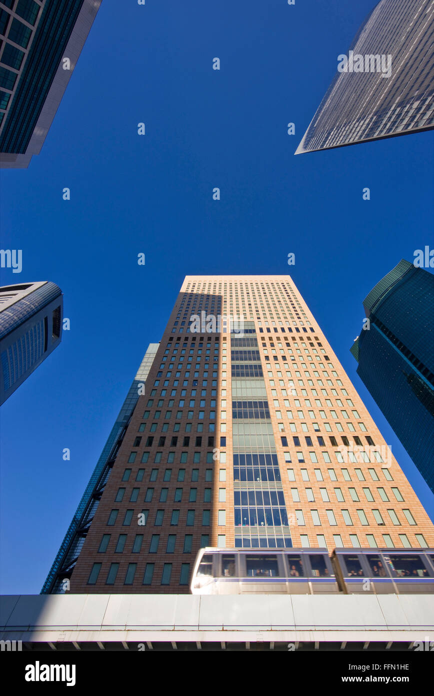 Eine niedrige Weitwinkelansicht fängt einen vorbeifahrenden Zug auf die erhöhten Yurikamome-Linie und viele der neuen Wolkenkratzer des Shiodome Stockfoto