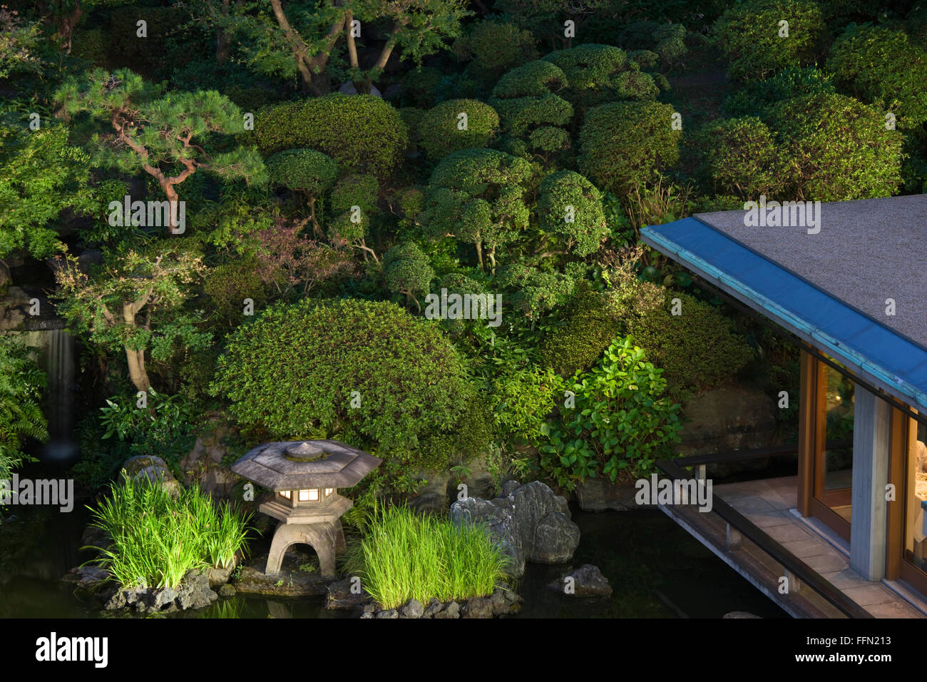 Eine Steinlaterne leuchtet in der Dämmerung in den traditionellen japanischen Garten im International House im Stadtteil Roppongi Stockfoto
