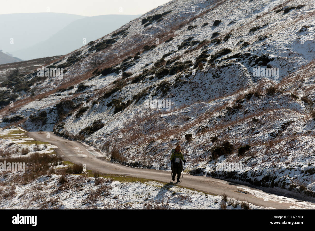 Heu-Bluff - Brecon-Beacons-Nationalpark, Powys, Wales, UK. 16. Februar 2016. UK-Wetter: Ein Wanderer Spaziergänge entlang der Straße am Evangelium Pass in der Nähe von Heu Bluff - in der Nähe von Hay-on-Wye - im östlichen Sektor der Brecon Beacons (die Black Mountains) in Powys, Wales, Vereinigtes Königreich. Vor einer Woche fiel Schnee liegt immer noch auf den Gipfeln des Brecon Beacons. Heute Morgen sind die Temperaturen mehrere Grad Celsius unter Null, aber mit mäßiger Wind die "gefühlte" Temperatur ist auf minus 5-8 Grad Celsius. Bildnachweis: Graham M. Lawrence/Alamy Live-Nachrichten. Stockfoto