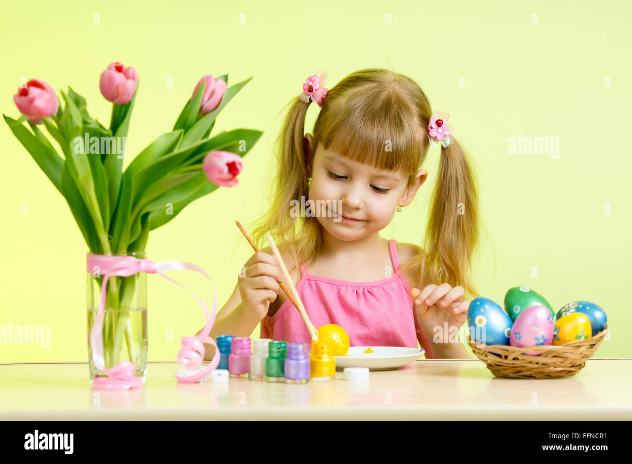 Kind Mädchen mit Pinsel Ostereier färben Stockfoto