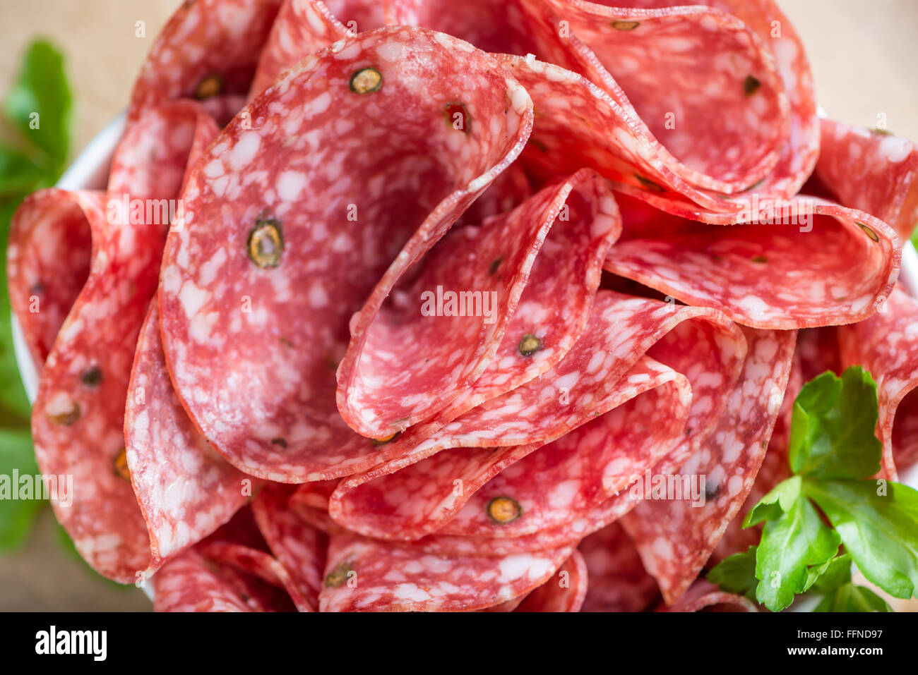 Alten Holztisch mit in Scheiben geschnittene Salami (Tiefenschärfe) Stockfoto