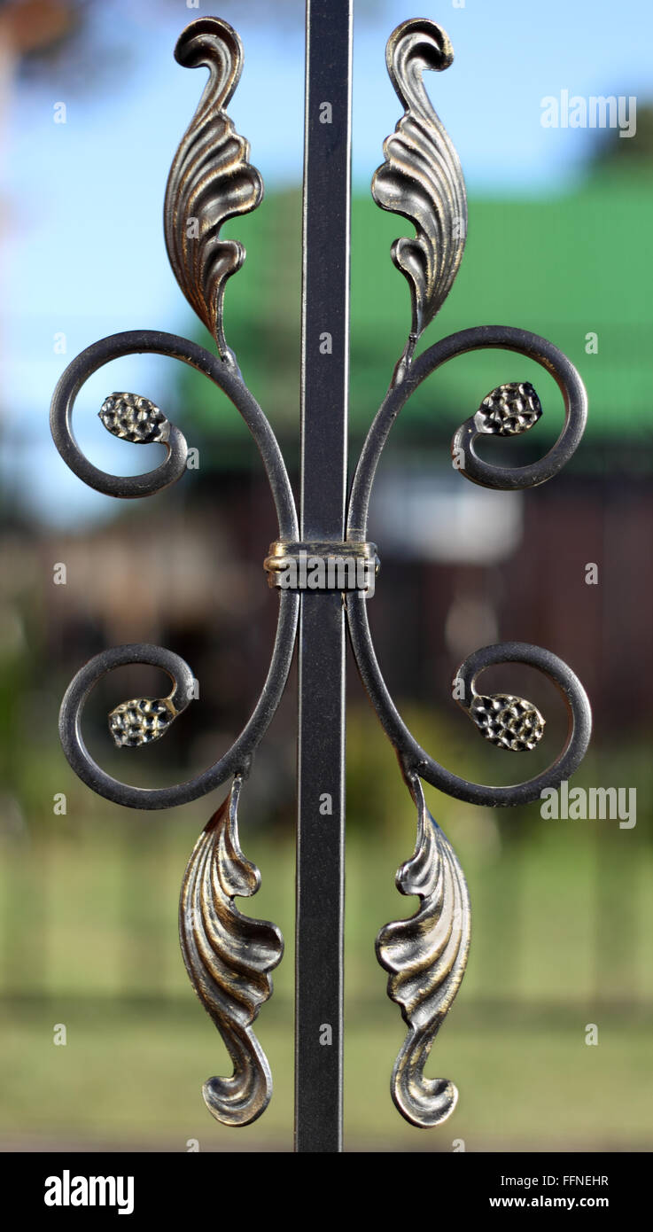 Exquisite geschmiedete Bronze Zaunelement über defokussierten Hintergrundfoto Stockfoto