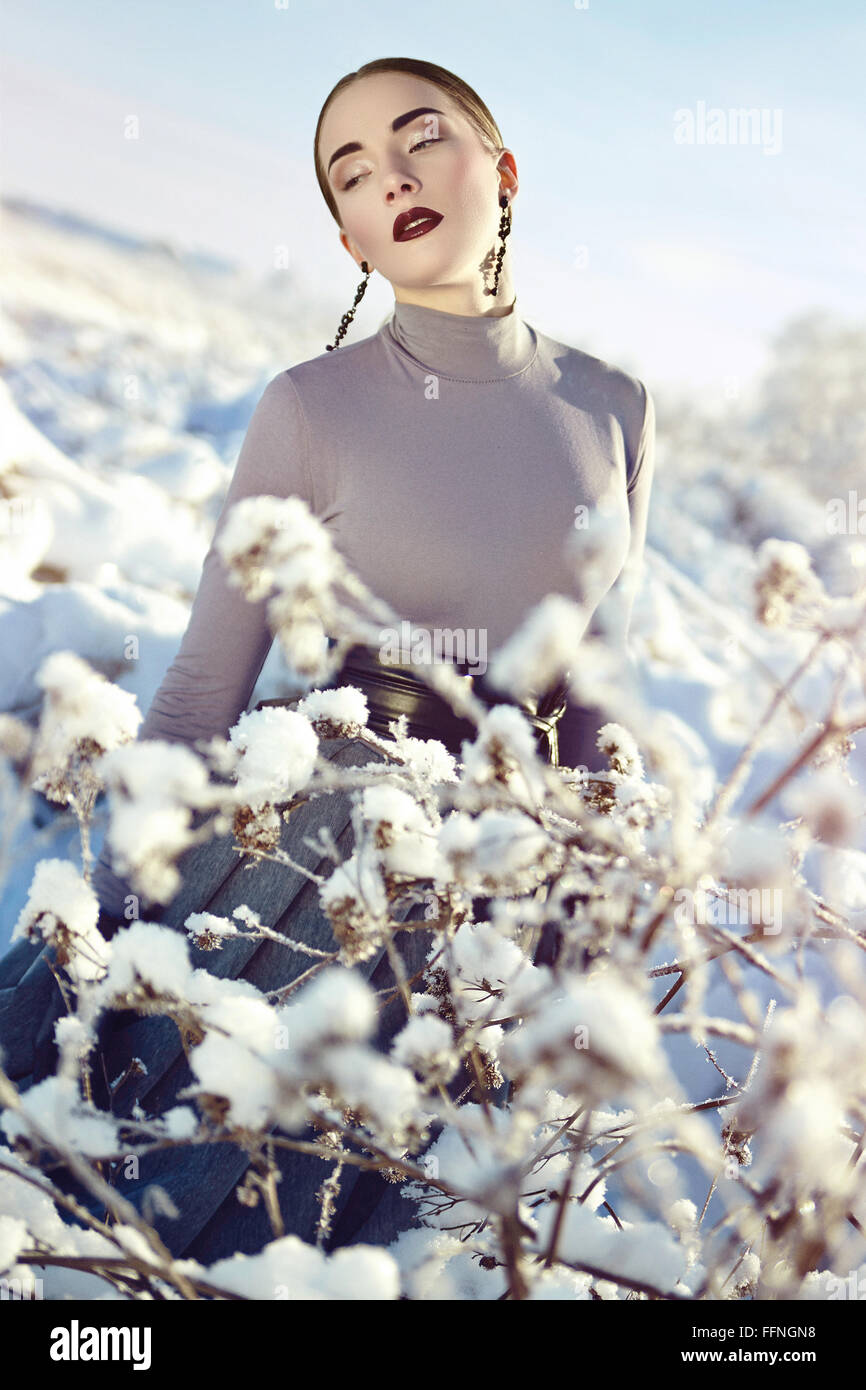 Die Schneekönigin. Wintertag. Luxuriöses Kleid. Das Mädchen im Schnee. Schwarze Ohrringe. Stockfoto