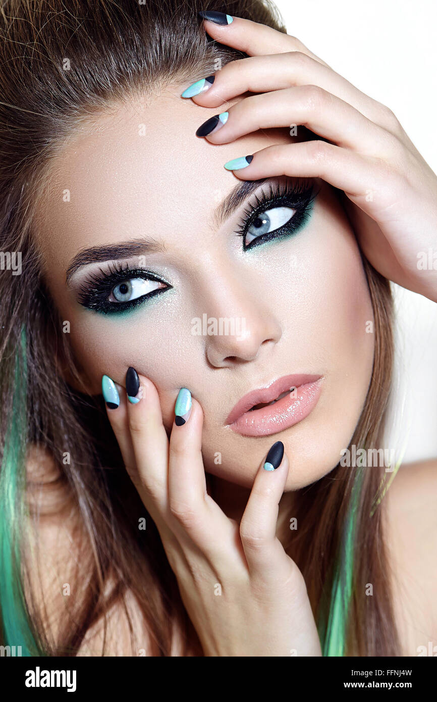 Ein Mädchen mit hellen Make-up. Die Krallen sind schwarz und weiß. Maniküre. Stockfoto