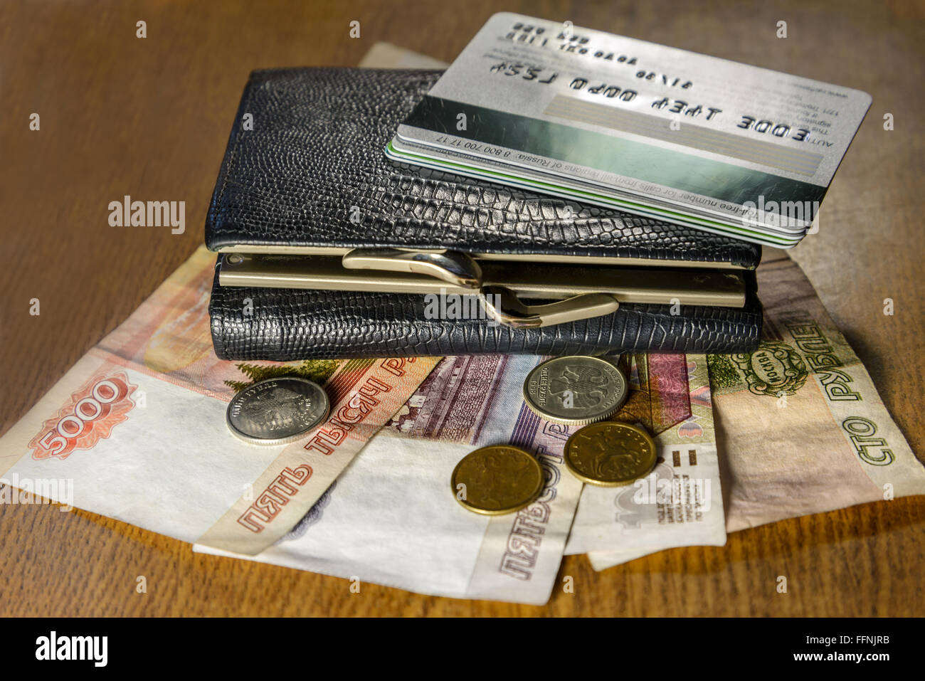 Geldbörse mit Kreditkarten und Bargeld auf einem Holztisch liegend Stockfoto