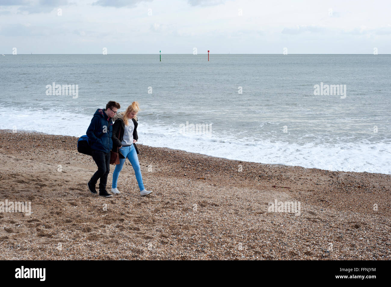 junges Paar zu Fuß auf Southsea Strand neben dem Solent England uk Stockfoto