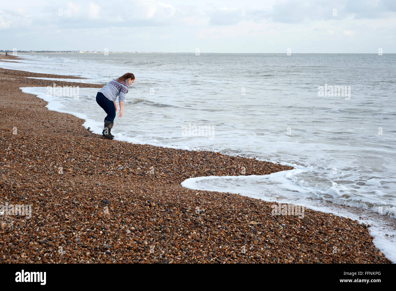junge Frau waschen mit Meerwasser am Strand von Southsea England uk Stockfoto