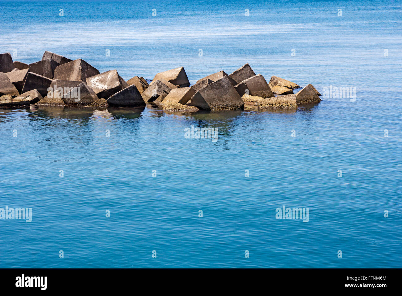 Massivem Stein und Staumauer am Meer Stockfoto