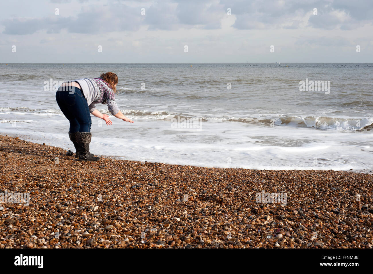 junge Frau waschen mit Meerwasser am Strand von Southsea England uk Stockfoto