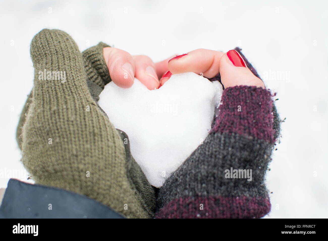 jungen und Mädchen die Hand, die ein Herz aus Schnee gemacht Stockfoto