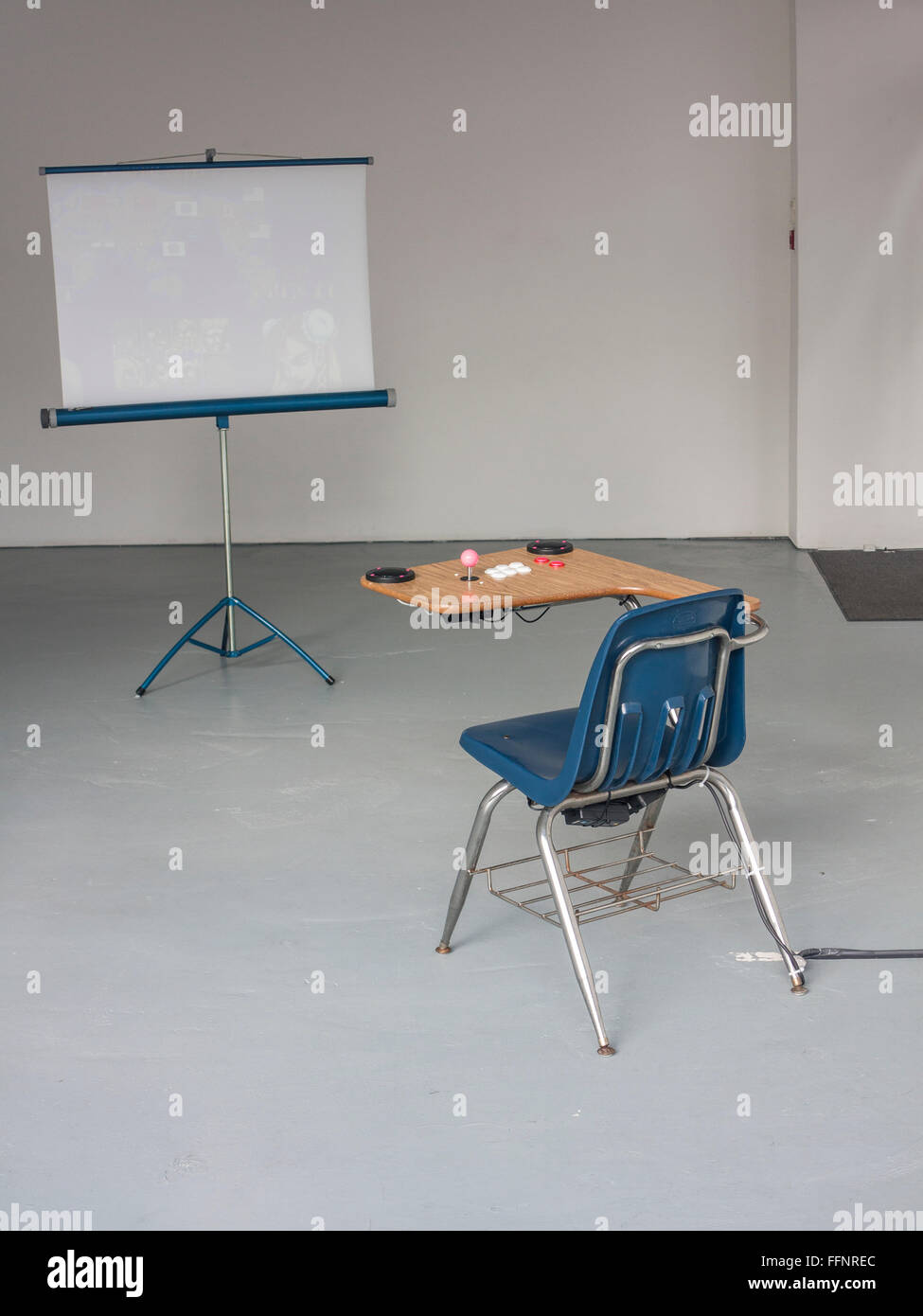 Einen Schreibtisch und ein Stuhl mit einem Bildschirm in einem leeren Raum Stockfoto