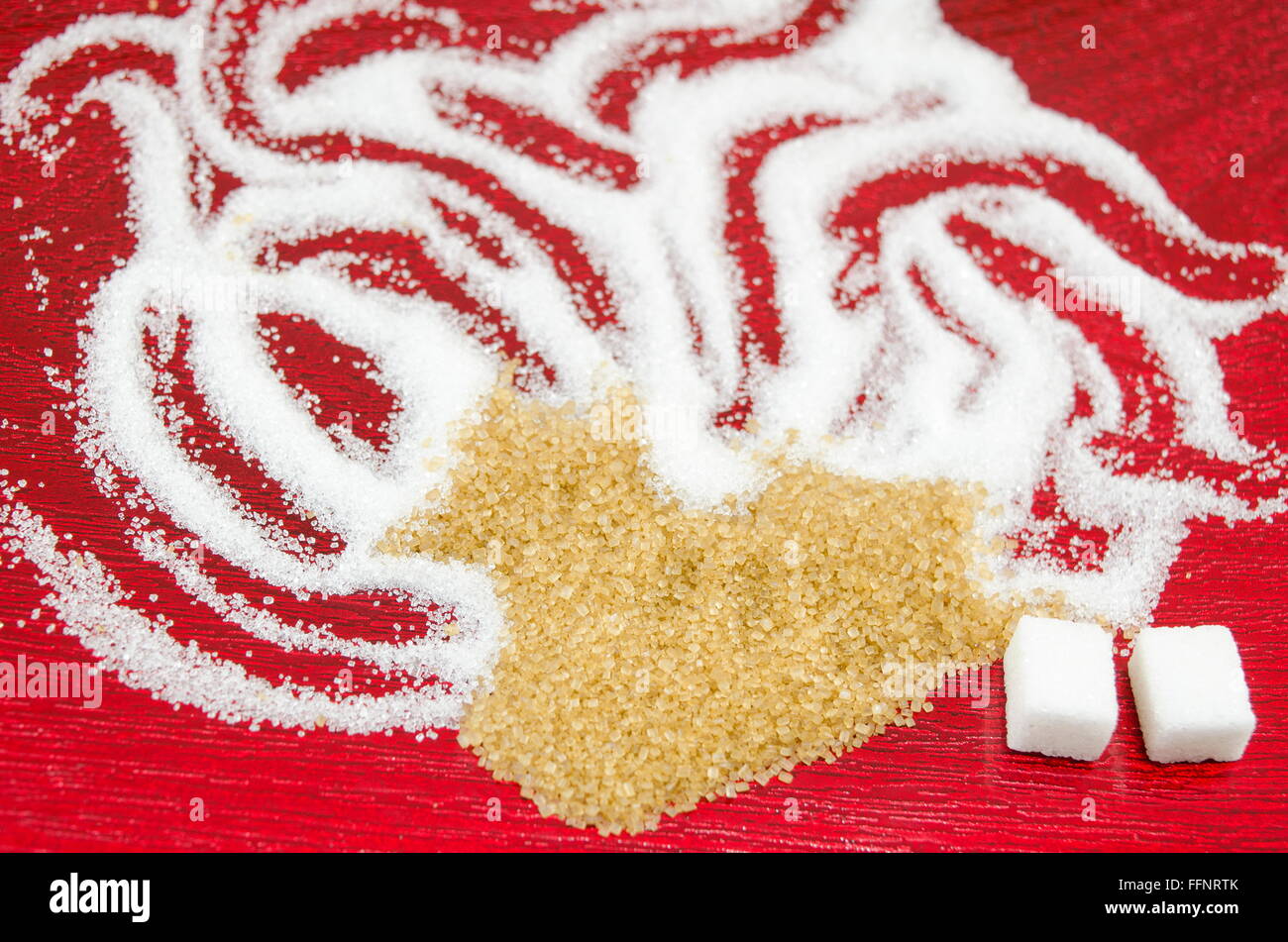 Weißer und brauner Zucker Formen auf rotem Grund Stockfoto