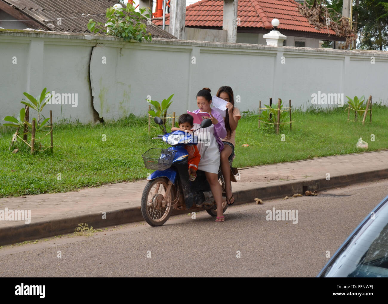 Frauen und junge auf Moped in Asien lesen Stockfoto