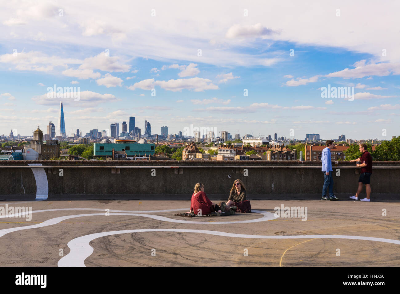 Zwei Mädchen und zwei Jungs Bier trinken auf dem Boden der Franken Cafe Bar auf der Dachterrasse Café in Peckham, kühl und im Südosten von London Stockfoto