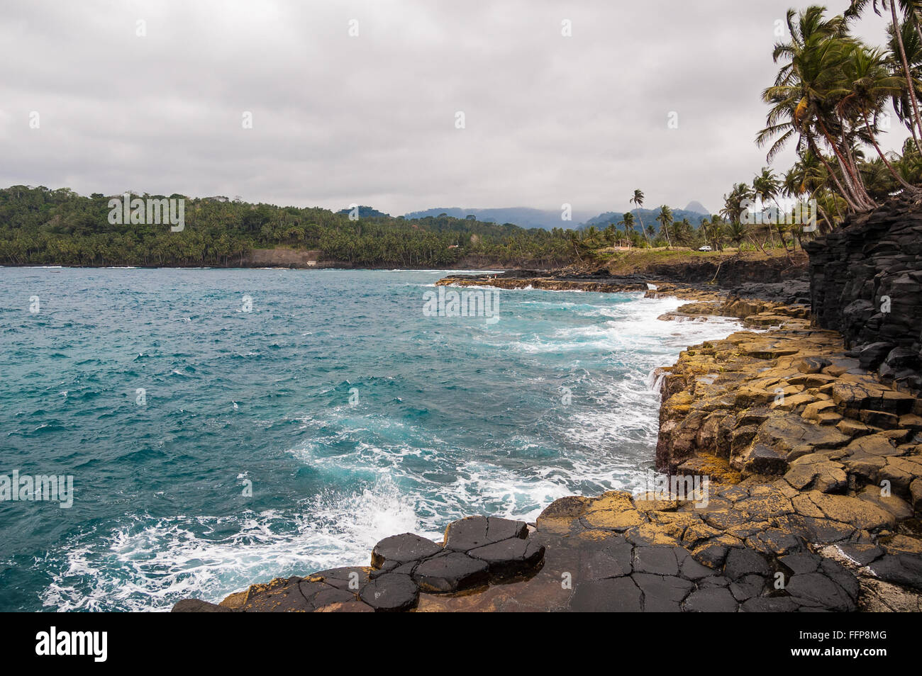 Klippen an einem tropischen Strand mit Palmen und makellosen blauen Meer. Boca do Inferno, Sao Tome und Principe. Stockfoto