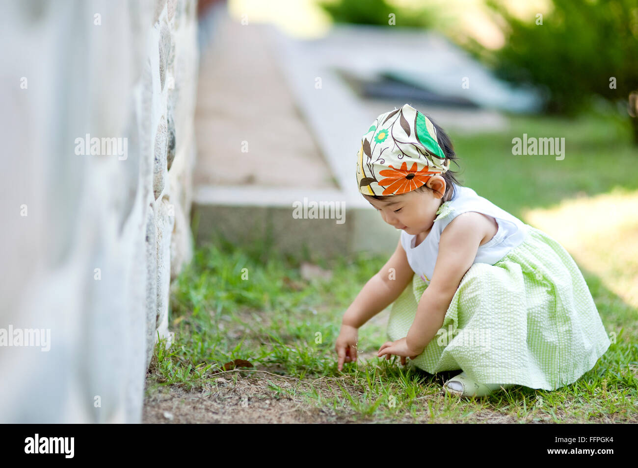 Kleines Baby berühren den Rasen, Asien Südkorea Stockfoto