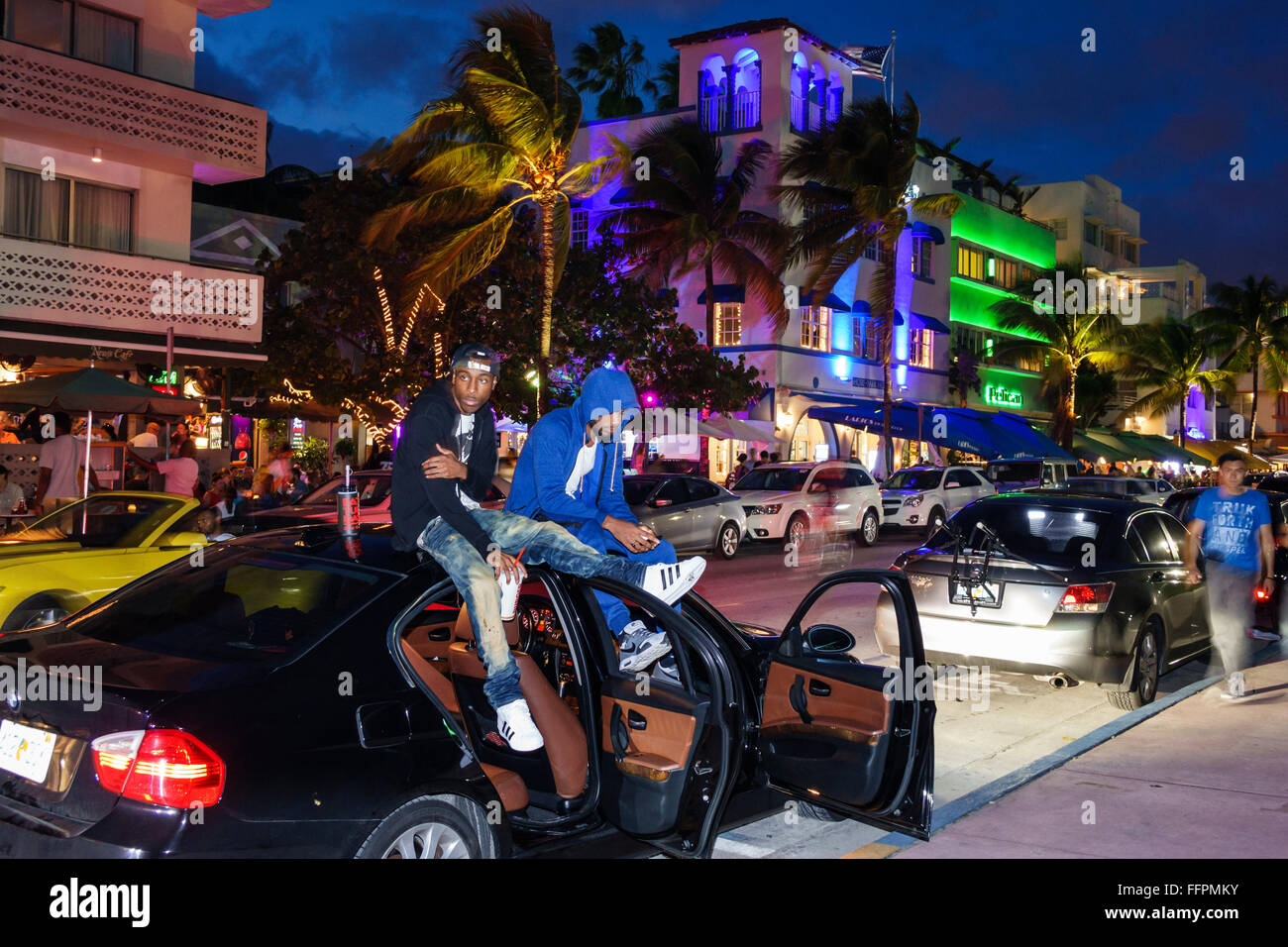 Florida South, Miami Beach, Ocean Drive, Nachtabend, schwarzer Erwachsener, Erwachsene, Mann, Männer, Freund, sitzender Wagen, FL151207034 Stockfoto