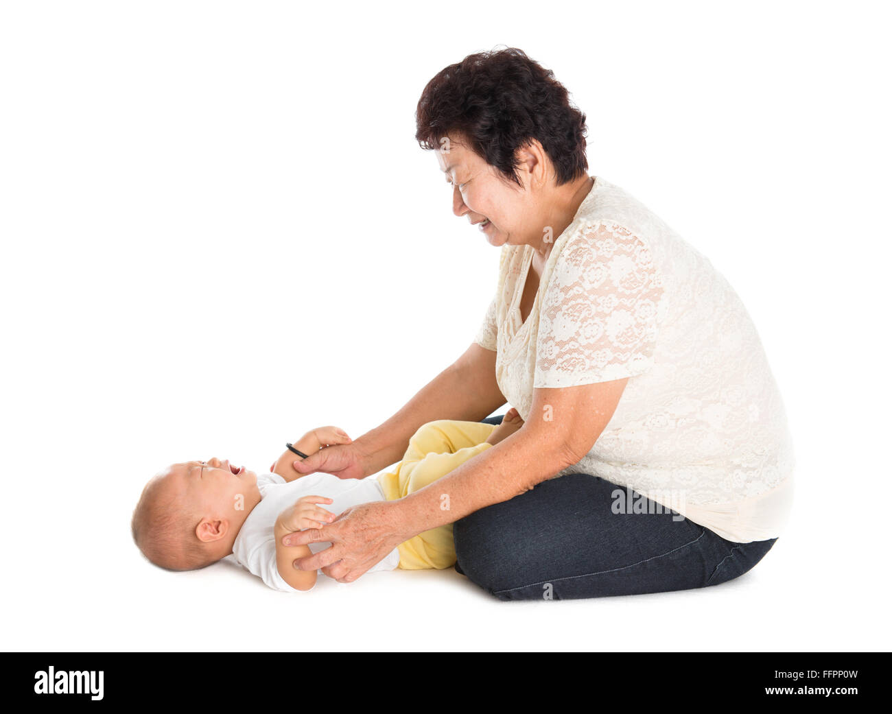 Großmutter beruhigend weinenden Enkel. Isoliert auf weißem Hintergrund. Stockfoto
