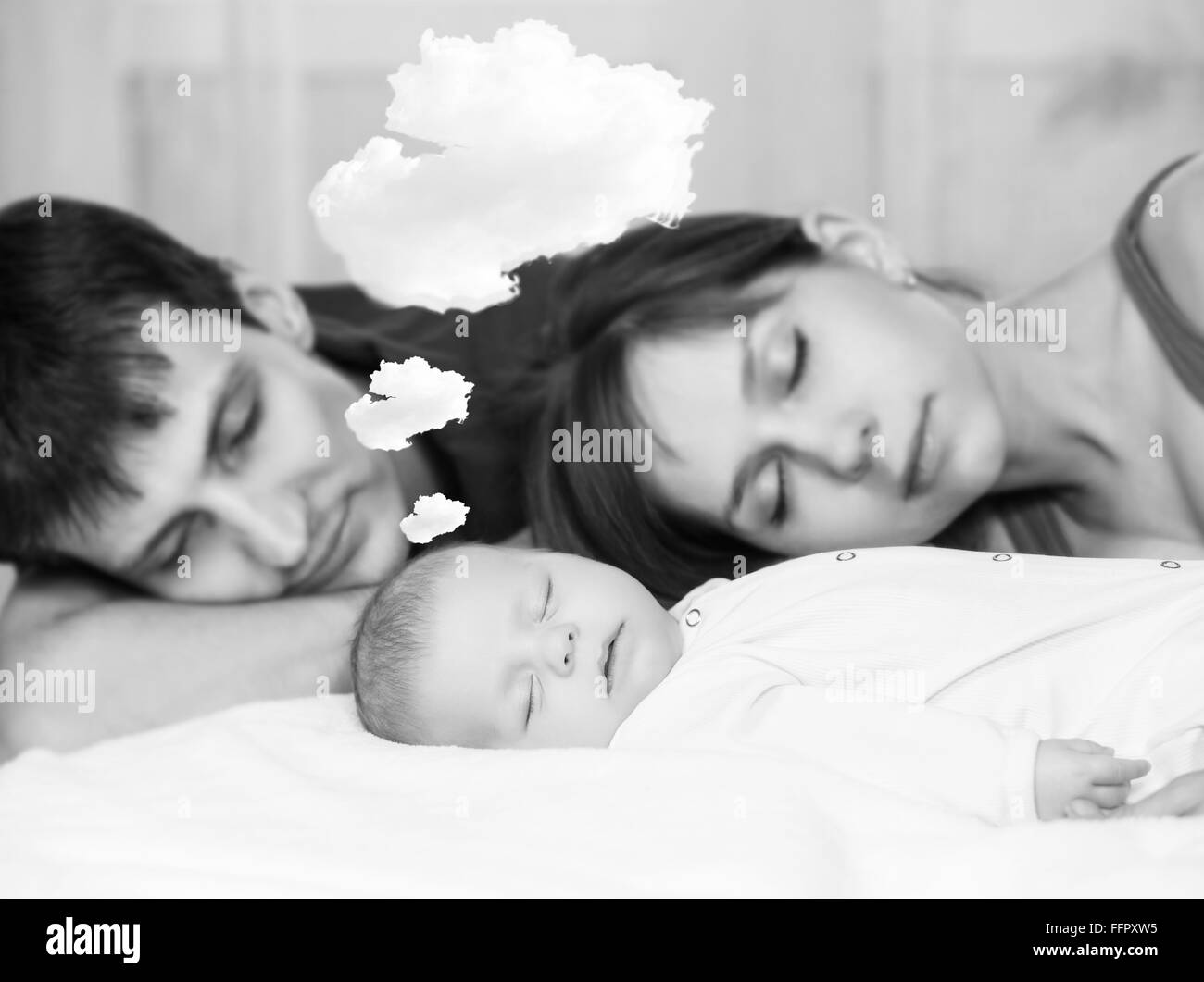 Schöne Baby schläft und träumt mit müde Eltern Stockfoto