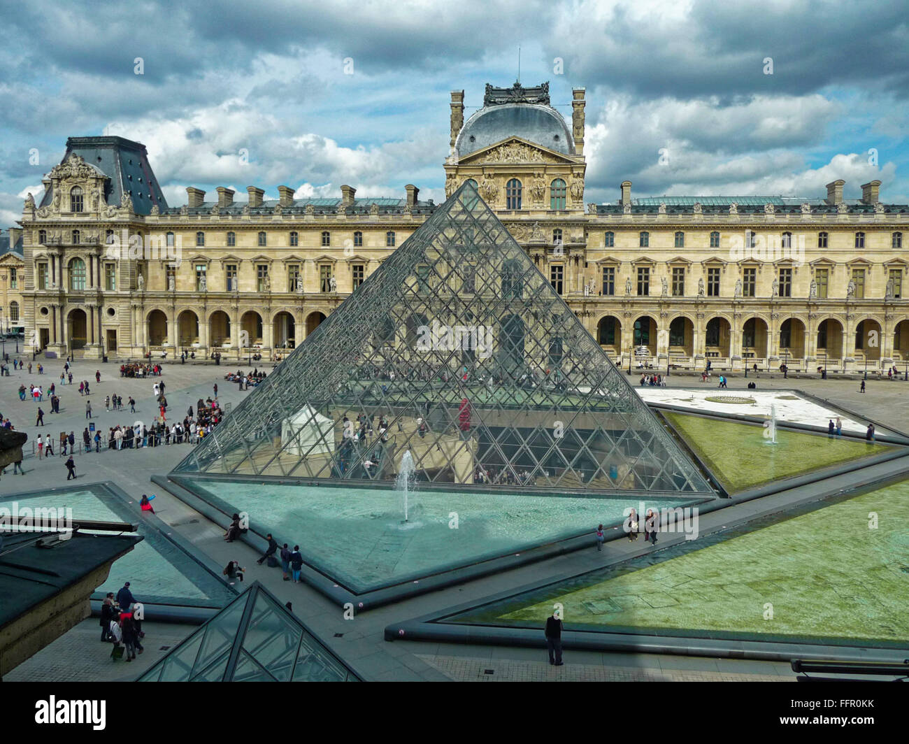 Der Louvre, Paris mit Blick auf die Pyramide und Gewitterwolken im Hintergrund Stockfoto