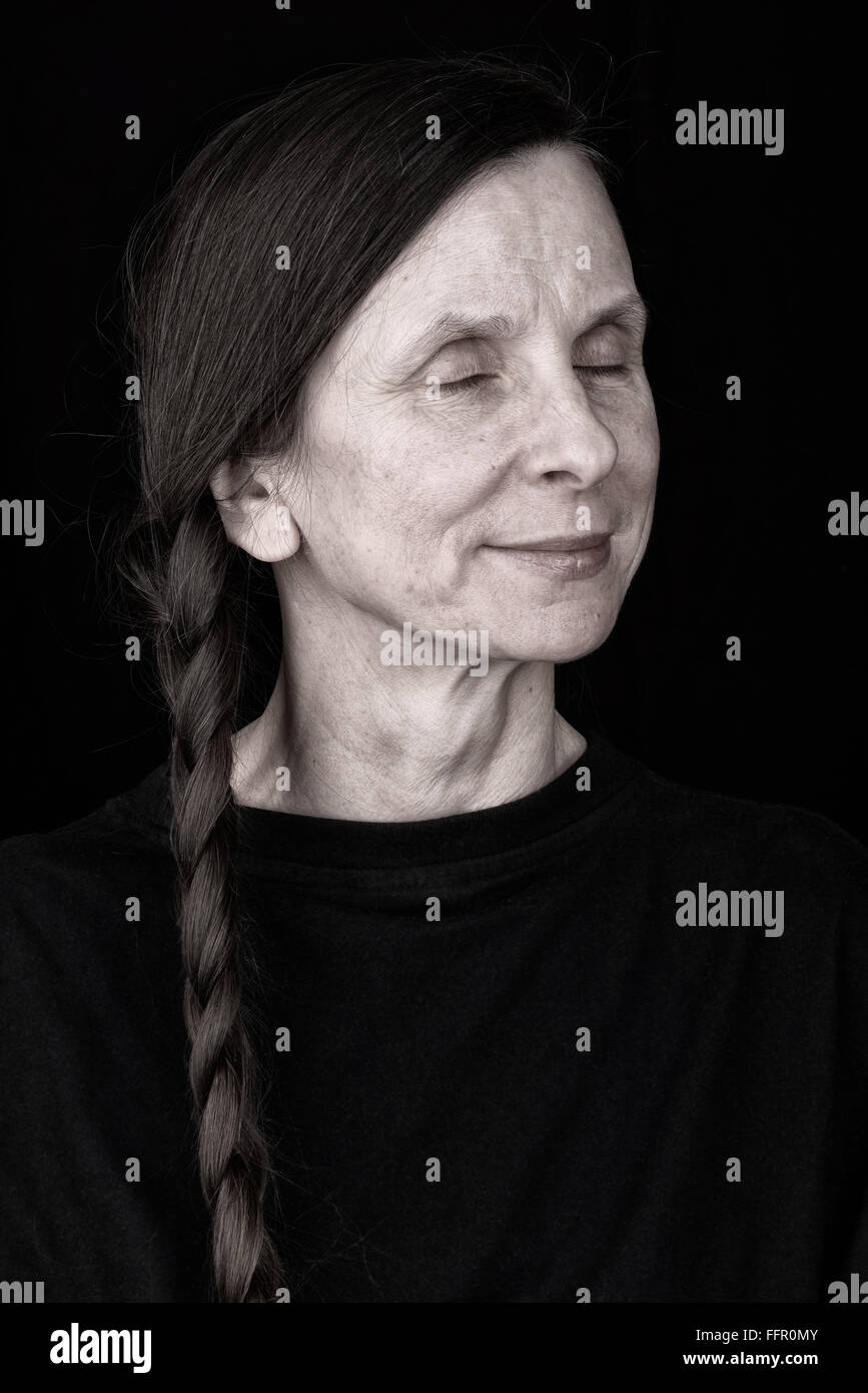 Porträt einer denken Erwachsene Frau mit Zopf und geschlossenen Augen Stockfoto