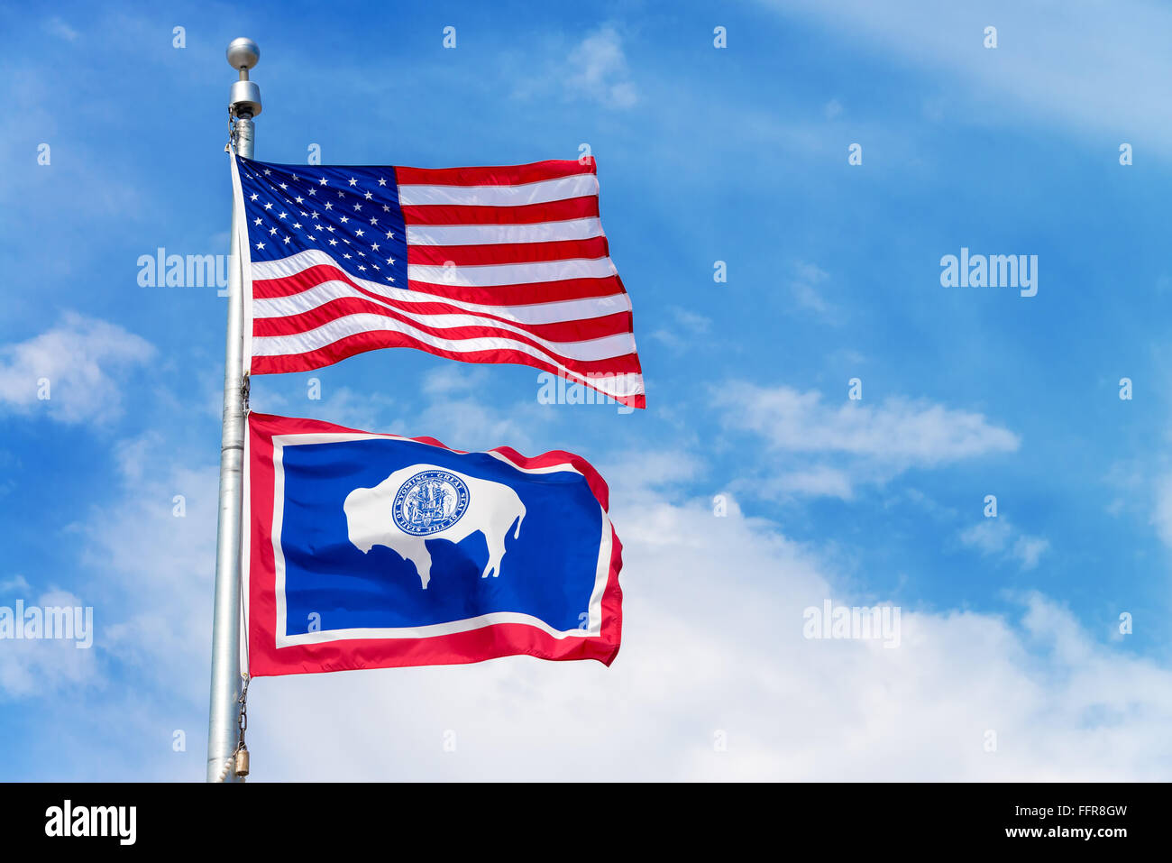 Amerikanische Flagge eine Fahnenstange mit der Wyoming Zustand-Markierungsfahne Stockfoto