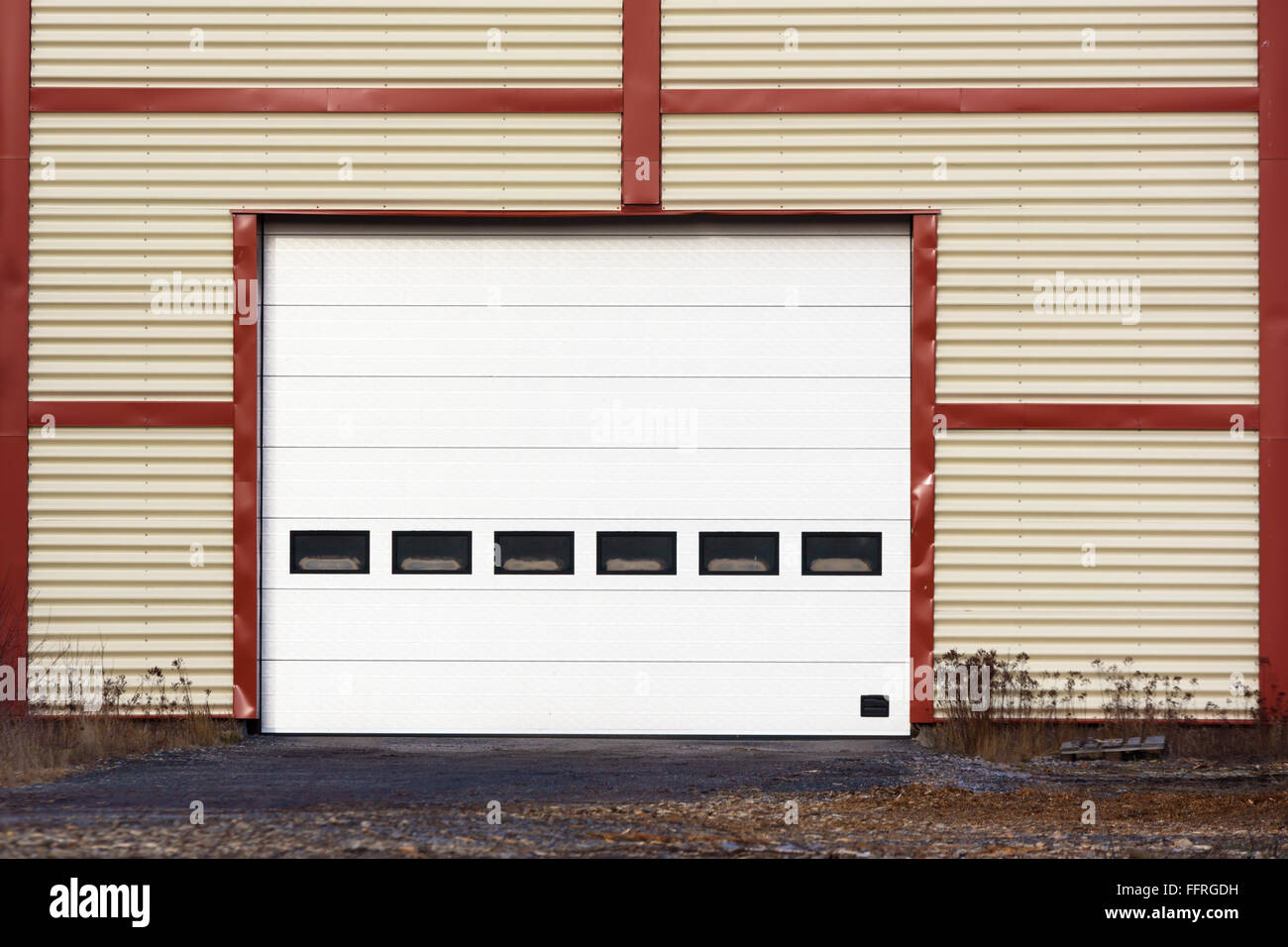 Große industrielle Garagentor auf einem roten und gelben Gebäude. Stockfoto