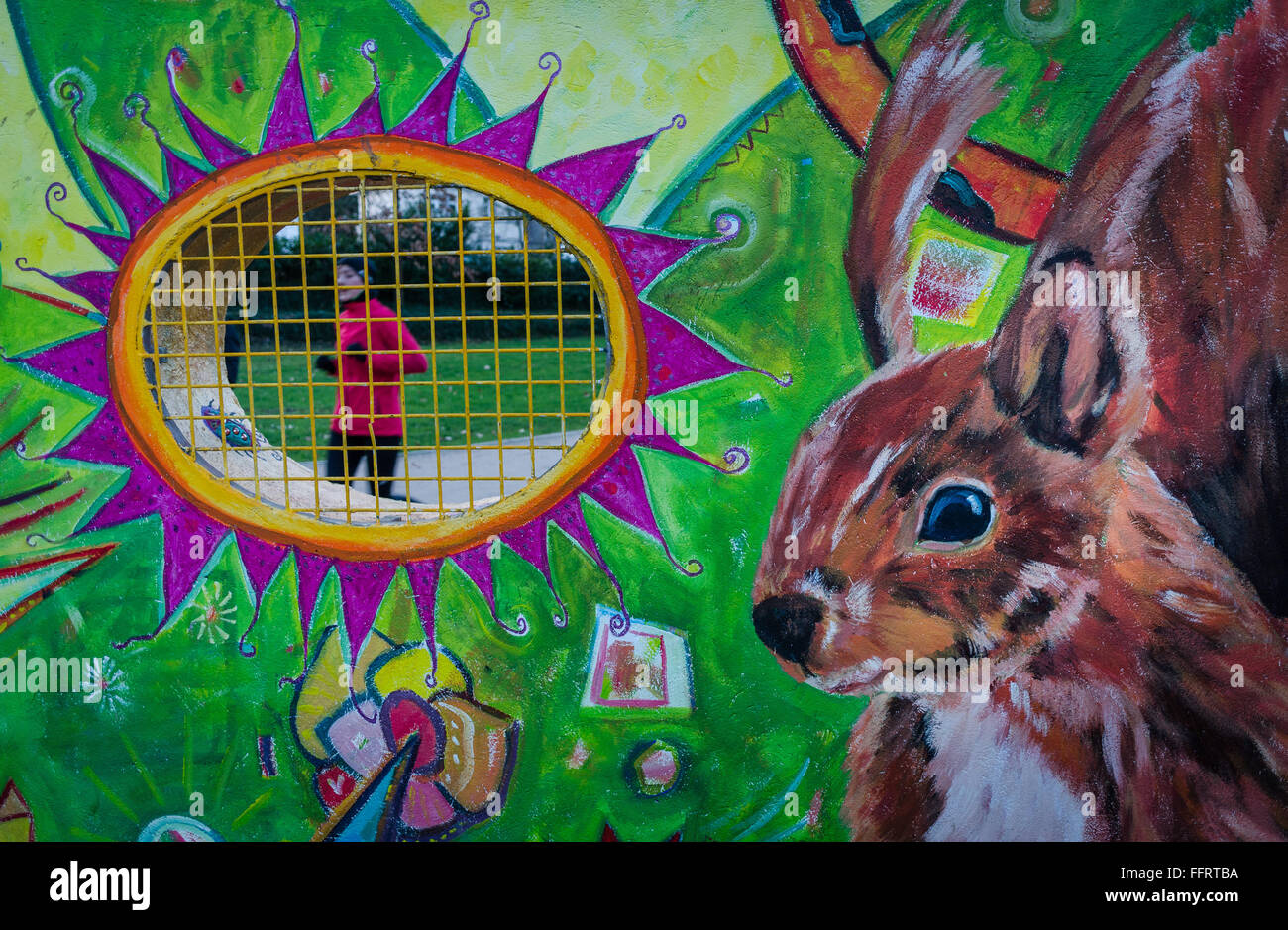 Ein Jogger führt vorbei an einem Fenster in einer Wand, auf der ein riesiges Eichhörnchen im Guenthersburg Park in Frankfurt Am Main, Deutschland, 16. Februar 2016 gemalt worden ist. Die Wandmalerei "Drei für die Wand" von den drei Malern Waechtler, Heidlas-Mai und Grambart-Delalic auf dem Park-Eingang wurde im Auftrag der Frankfurter Parks Commission. Foto: FRANK RUMOENHORST/dpa Stockfoto
