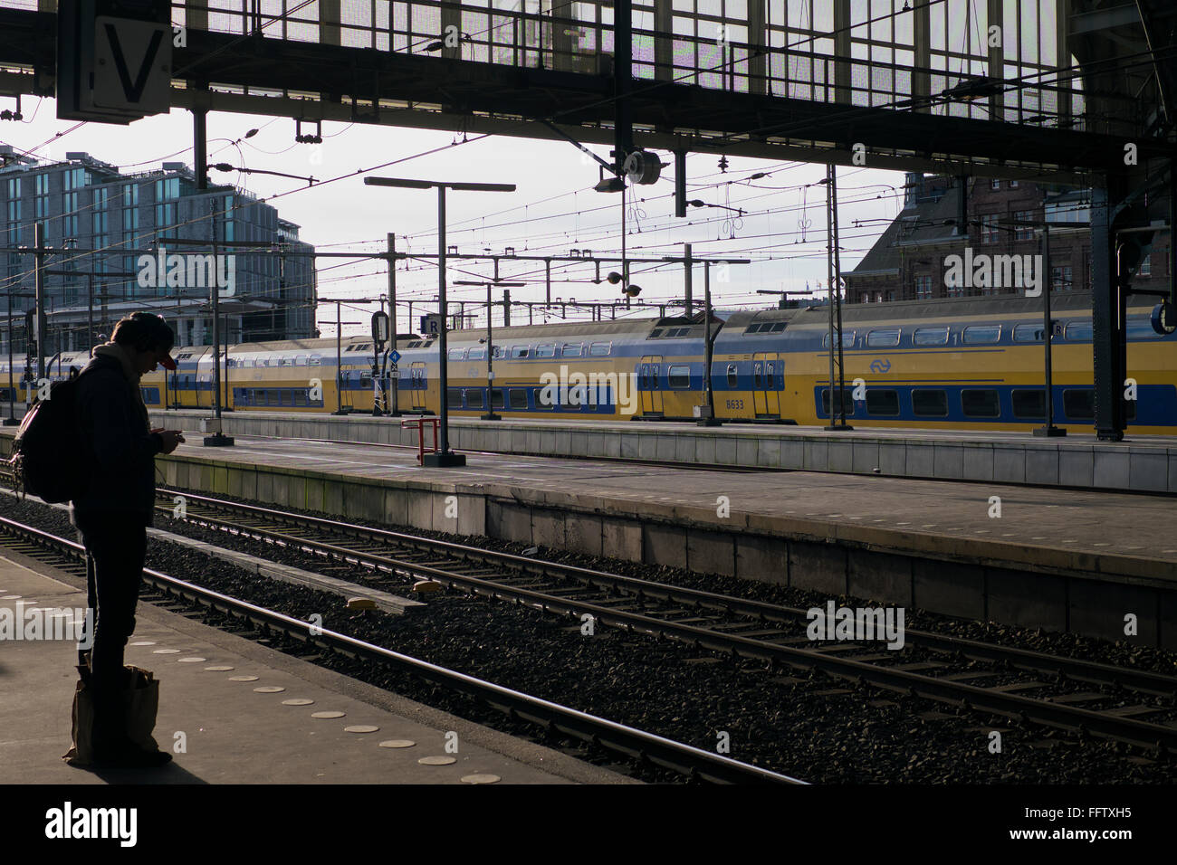 Passagier wartet Zug am Bahnhof Amsterdam Centraal in der Netherlannds Stockfoto