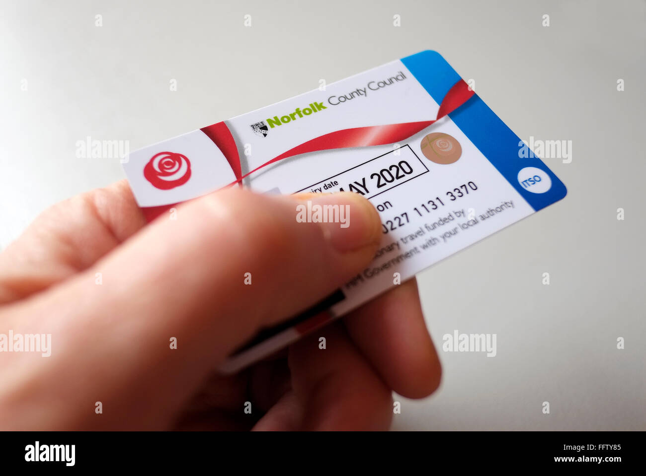 männliche Hand, die eine verbilligten Bus-Pass-Karte Stockfoto