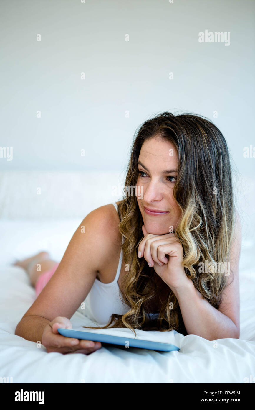 lächelnde Frau liegt auf ihrem Bett lesen Stockfoto lächelnde Frau liegt auf ihrem Bett lesen Stockfoto
