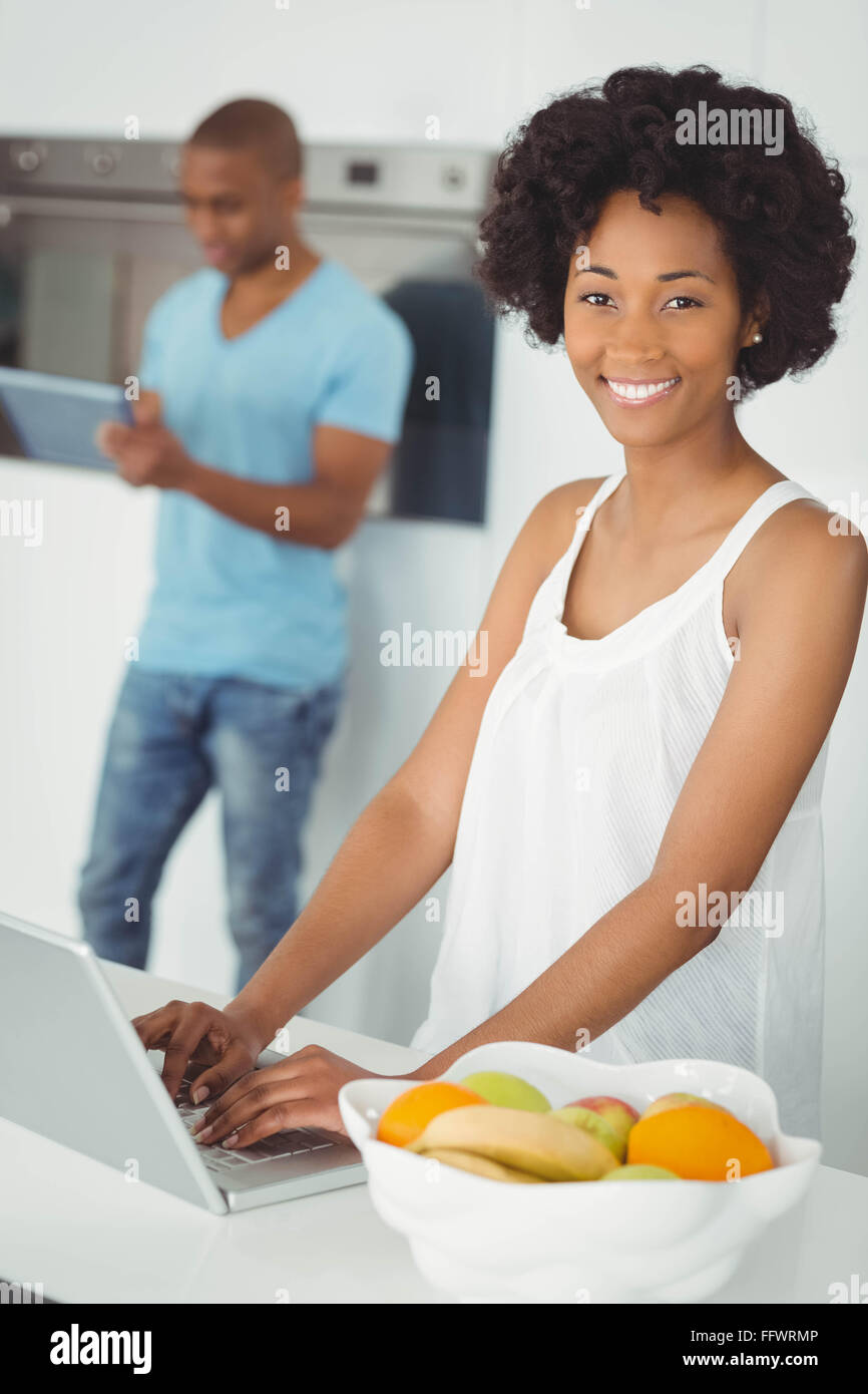 Lächelnde Frau in der Küche mit laptop Stockfoto