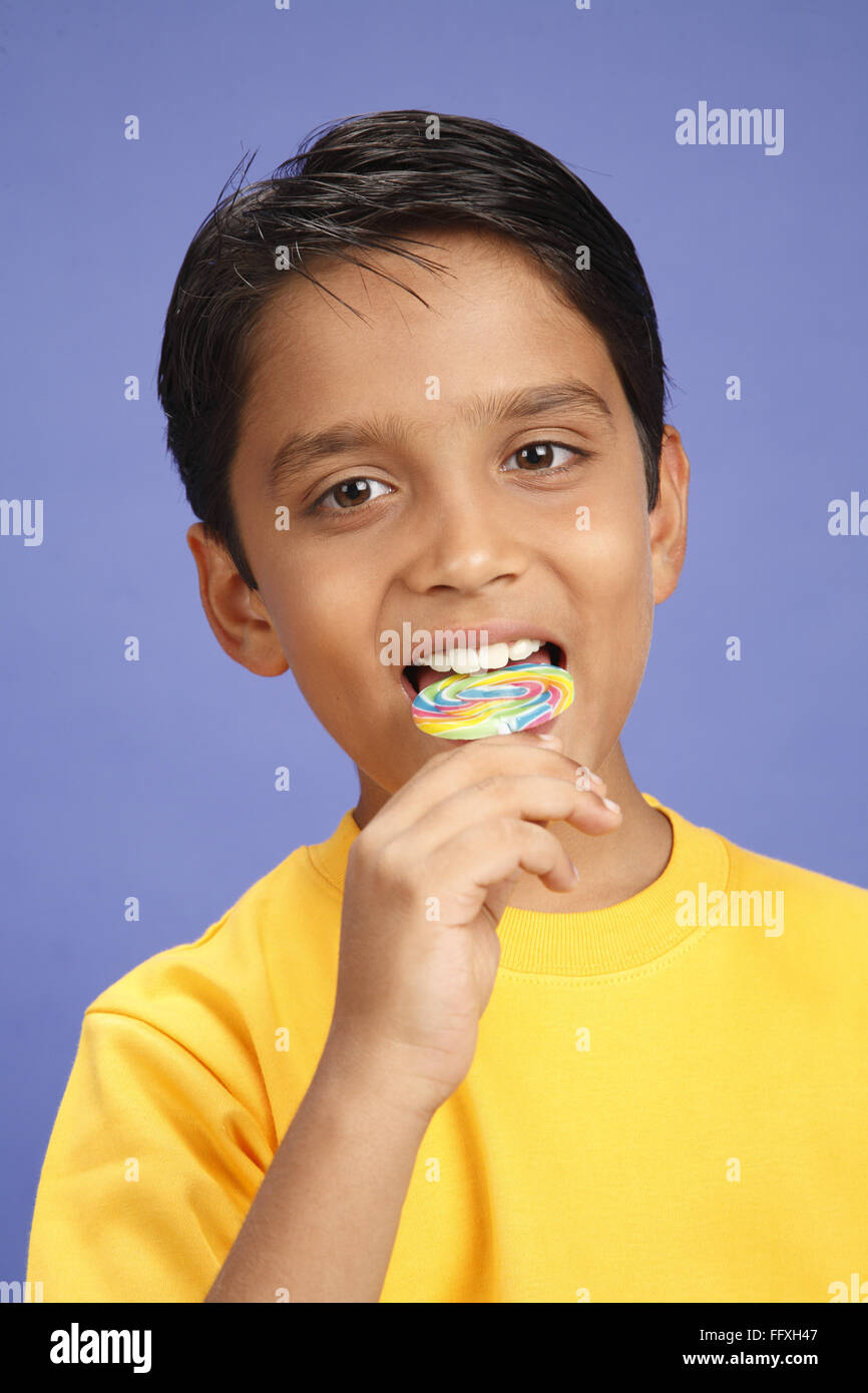 Zehn Jahre alter Junge hält große bunte Lutscher lecken Herr #703V Stockfoto