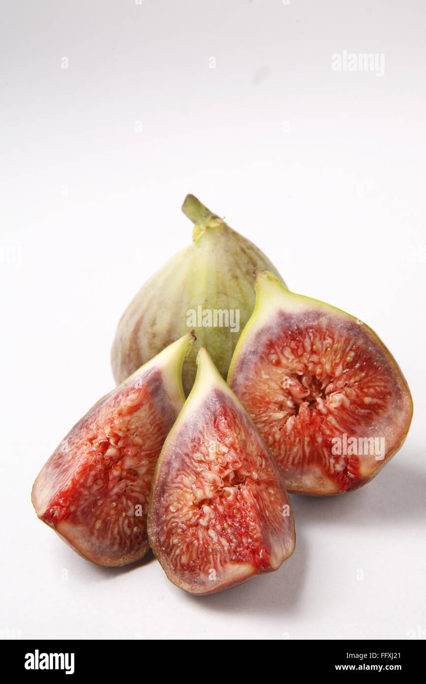Obst, Feigen Ficus Carica Anjir eine volle und ein weiterer Schnitt in drei Stücke rote saftige Textur auf weißem Hintergrund Stockfoto