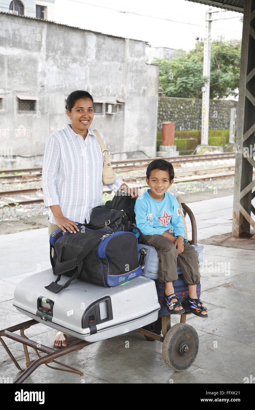 Mutter stand und Sohn sitzen auf Gepäck gehalten auf Wagen Herr #468 Stockfoto