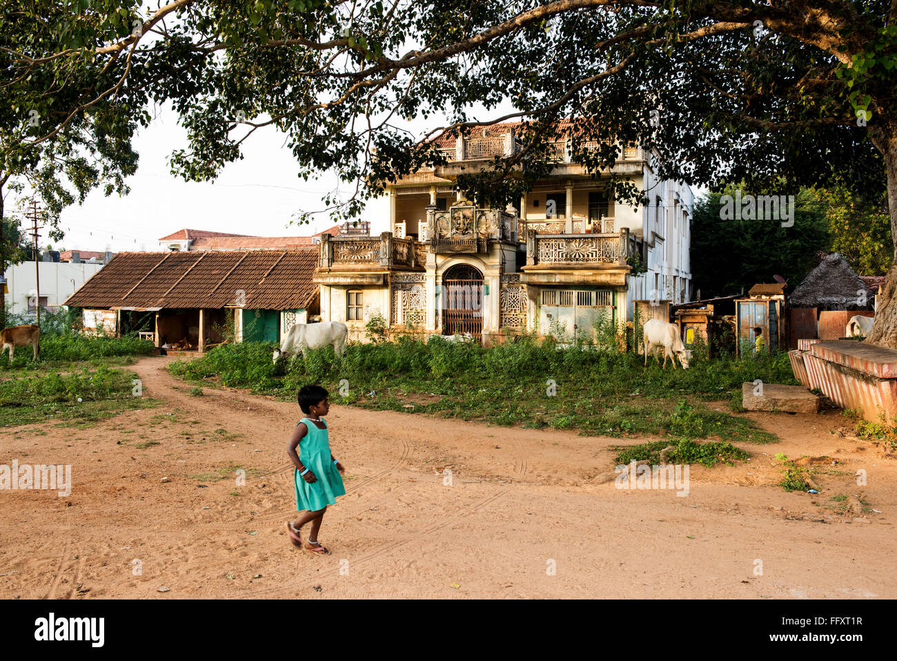 Eine junge Inderin geht vorbei an einem Händler Haus im Dorf Kundrikudy in der Nähe von Chettinad, Tamil Nadu, Indien Asien Stockfoto