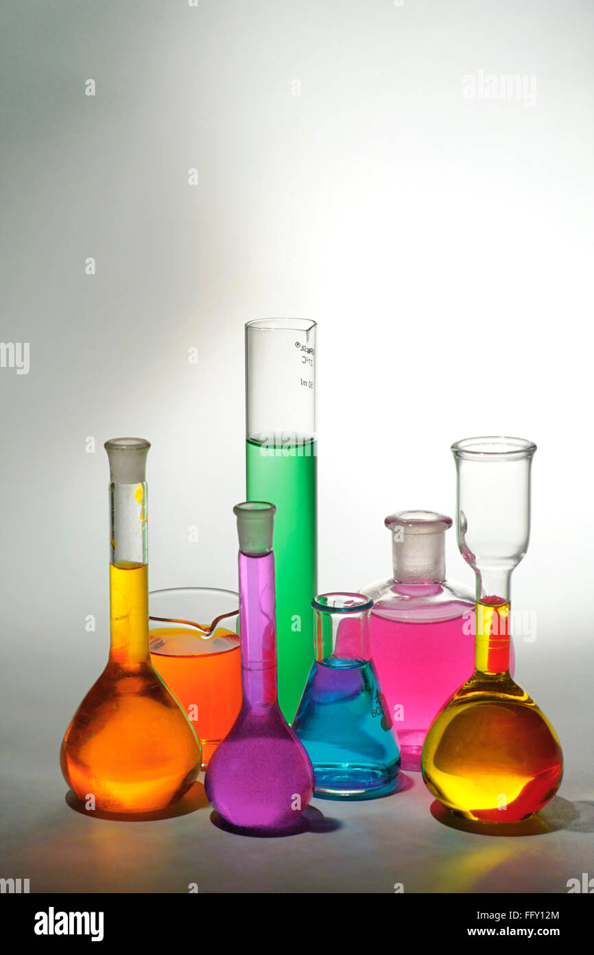 Konzept, verschiedene bunte Chemikalien im Becher auf weißem Hintergrund Stockfoto