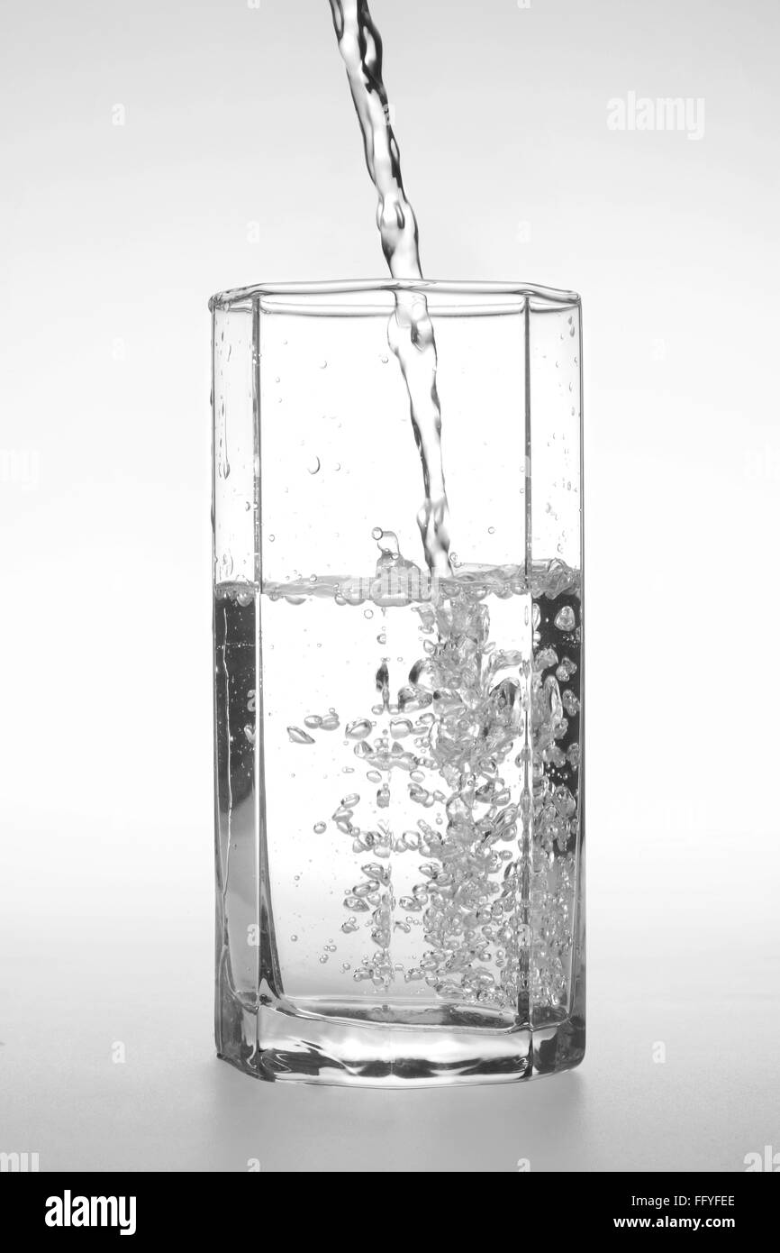 Gießen von Wasser in transparentem Kristallglas; Indien Stockfoto