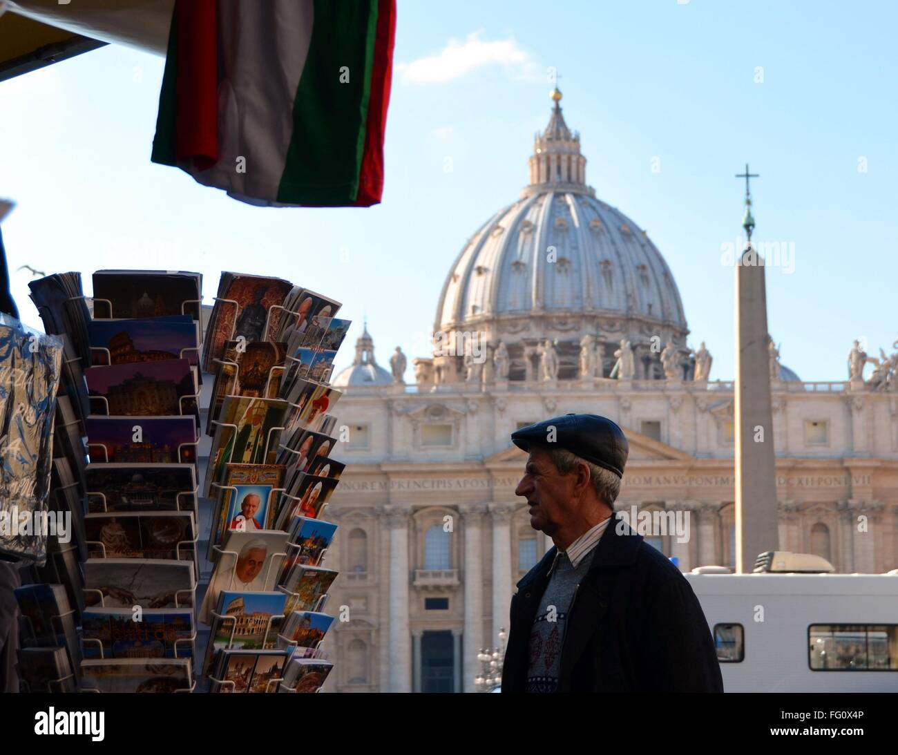 Ein älterer Mann sucht nach Postkarten, im Hintergrund die Kuppel des Petersdom in Rom. Stockfoto