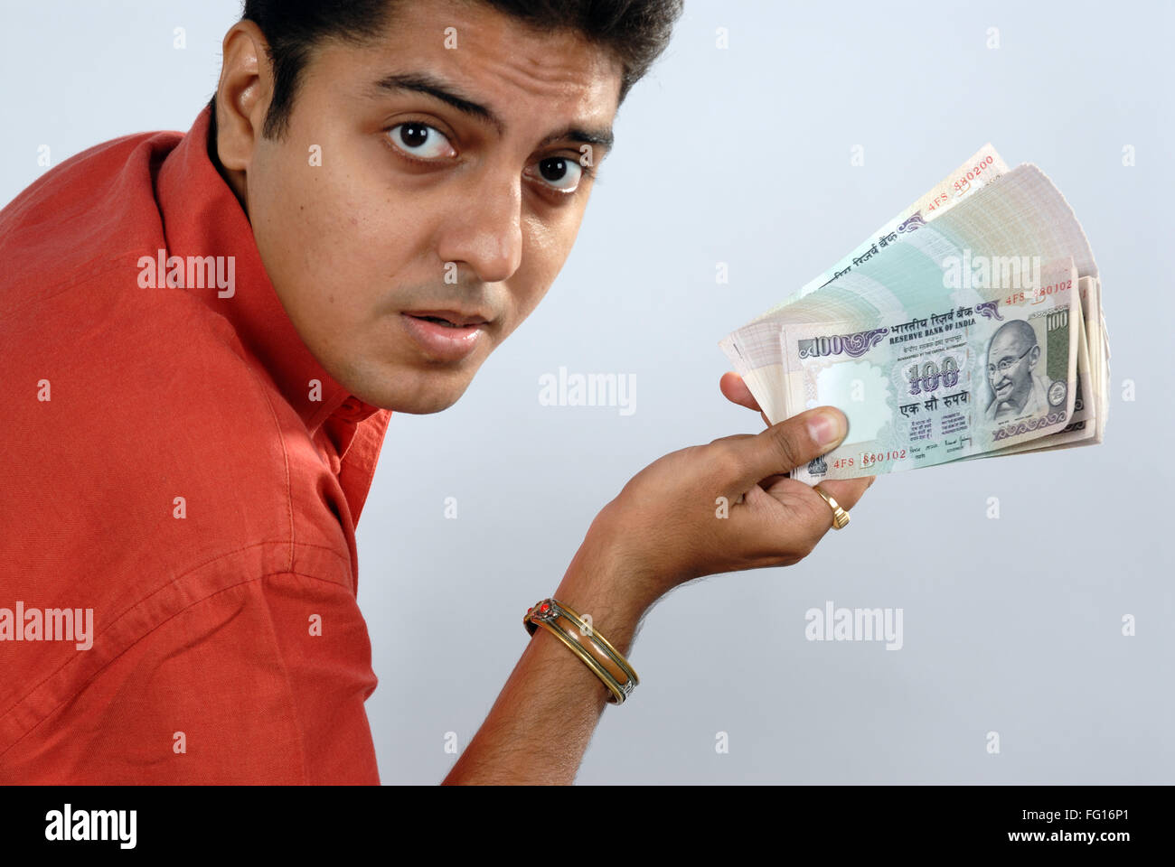 South Asian indischen Mann zeigt Bündel von hundert Rupien Noten Blick in die Kamera Herr #628 Stockfoto