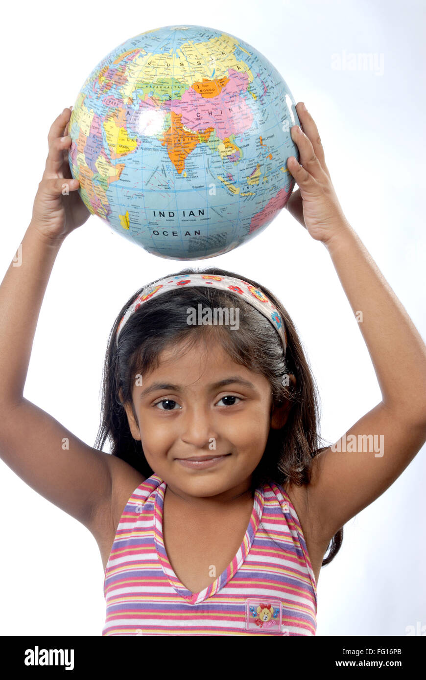 Südasiatische sechs Jahre alte Inderin halten Globus auf Kopf, Blick in die Kamera Herr #364 Stockfoto