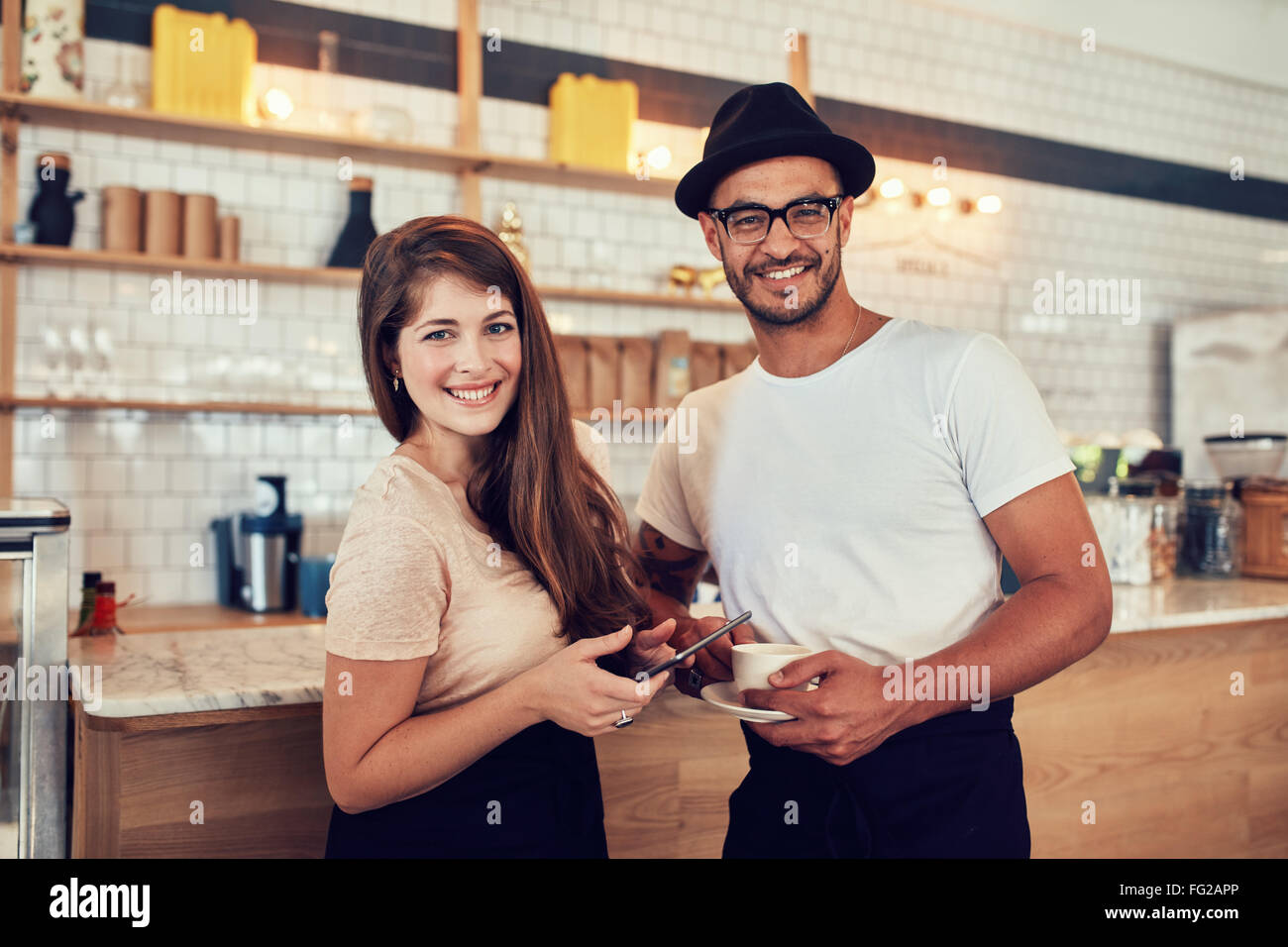 Porträt von glückliches junges Paar im Café bei einer Tasse Kaffee und digital-Tablette. Kaukasische paar zusammenstehen ein Café-Inter Stockfoto