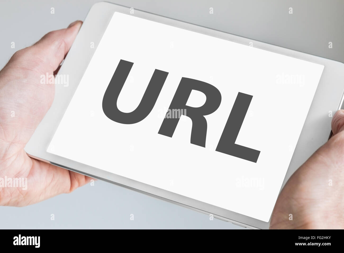 URL-Text auf Touch-Screen des modernen Tablet angezeigt. Hände halten weiße Mobilgerät Stockfoto