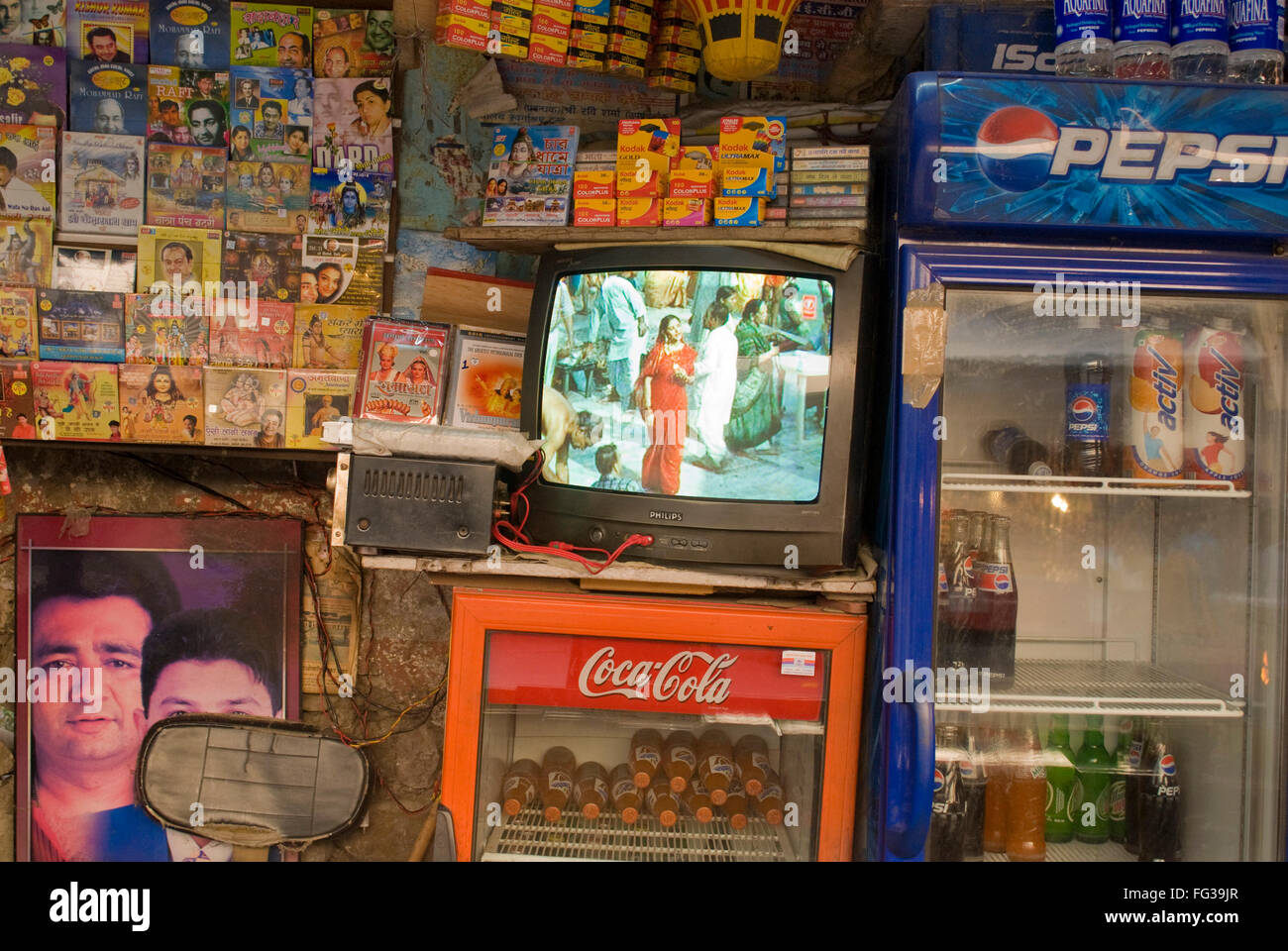 Fernsehspielen devotional Musik-Videos auf Coca Cola Kühlschrank gelegt; Rishikesh; Uttaranchal Uttarakhand; Indien Stockfoto
